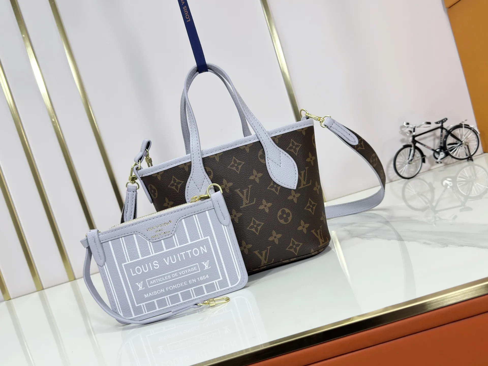 P240 M25656 M12099 Upgraded original Neverfull Bandouliere Inside Out BB handbag is a double-sided version of the classic design this season, with the front and back decorated with iconic Monogram canvas and grained leather. The removable zipper bag can be used alone or hung externally. The detachable shoulder strap makes it easy to wear cross-body, and the dazzling metal hardware adds a sophisticated detail. Dimensions: 26.5 × 16.5 × 11 cm
