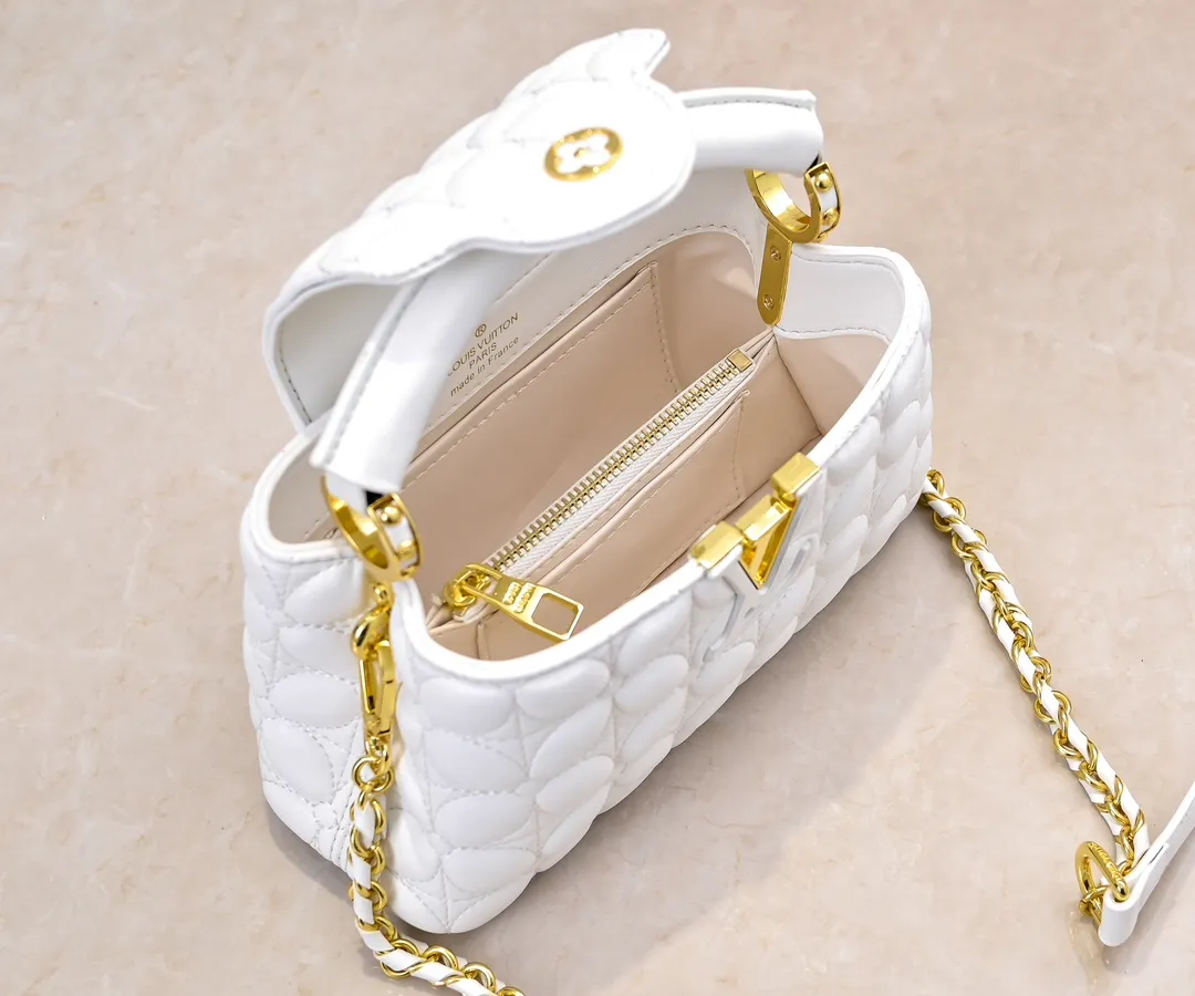 Upgraded version P420 M23998 White This Monogram embroidered flower emerges from the elegant quilting, bringing the style of Louis Vuitton store decoration to the Capucines mini handbag. Soft sheepskin creates a stable structure and trim, and the detachable shoulder strap allows for comfortable shoulder or cross-body wear. Dimensions: 22 x 12 x 8 cm