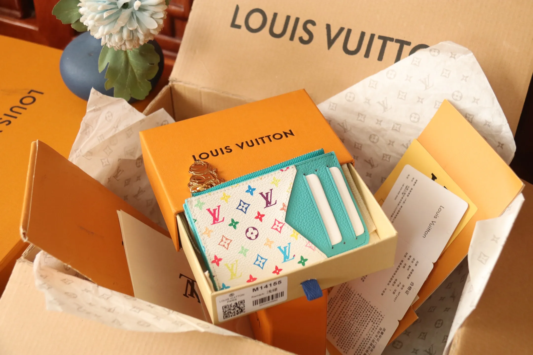 【LV x TM Romy Card Holder】 💎P400 m14155 Rose m14171 Blue m13800 Green "LV × TM Porto Kurt Romy" appears in the "Louis Vuitton × Takashi Murakami" series that unfolds in a variety of categories. It features functional and playful expressions with fresh tones inspired by the rainbow colors unique to Japanese artists. The whole piece is finished with Monogram Amplant leather that adds a casual personality, and the bright Monogram multi-color canvas in the flat pocket stands out. The coin pocket opens and closes with a gold zipper and features a panda pull to symbolize the season.  Dimensions: 12 x 8 x 0.8 cm