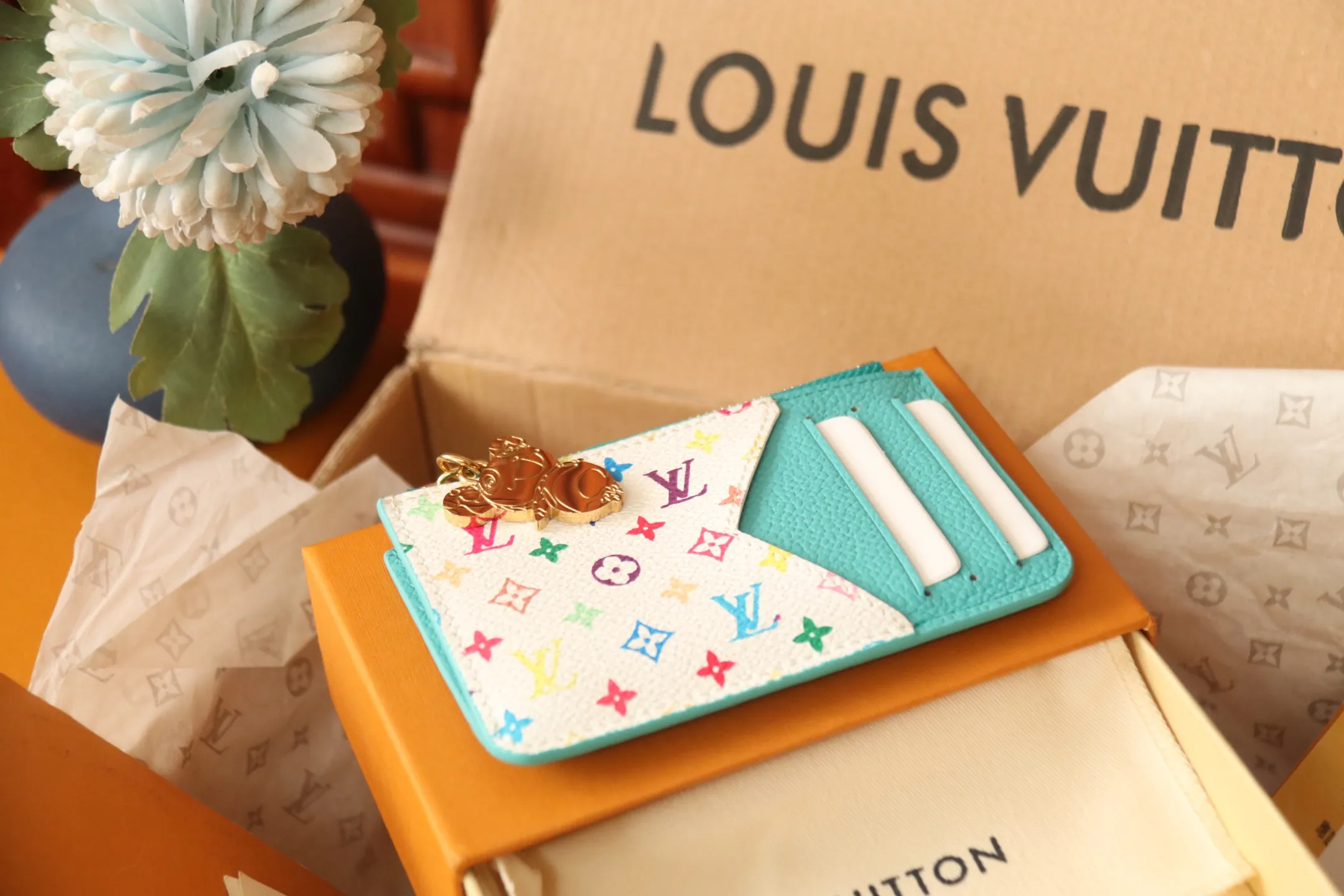 【LV x TM Romy Card Holder】 💎P400 m14155 Rose m14171 Blue m13800 Green "LV × TM Porto Kurt Romy" appears in the "Louis Vuitton × Takashi Murakami" series that unfolds in a variety of categories. It features functional and playful expressions with fresh tones inspired by the rainbow colors unique to Japanese artists. The whole piece is finished with Monogram Amplant leather that adds a casual personality, and the bright Monogram multi-color canvas in the flat pocket stands out. The coin pocket opens and closes with a gold zipper and features a panda pull to symbolize the season.  Dimensions: 12 x 8 x 0.8 cm