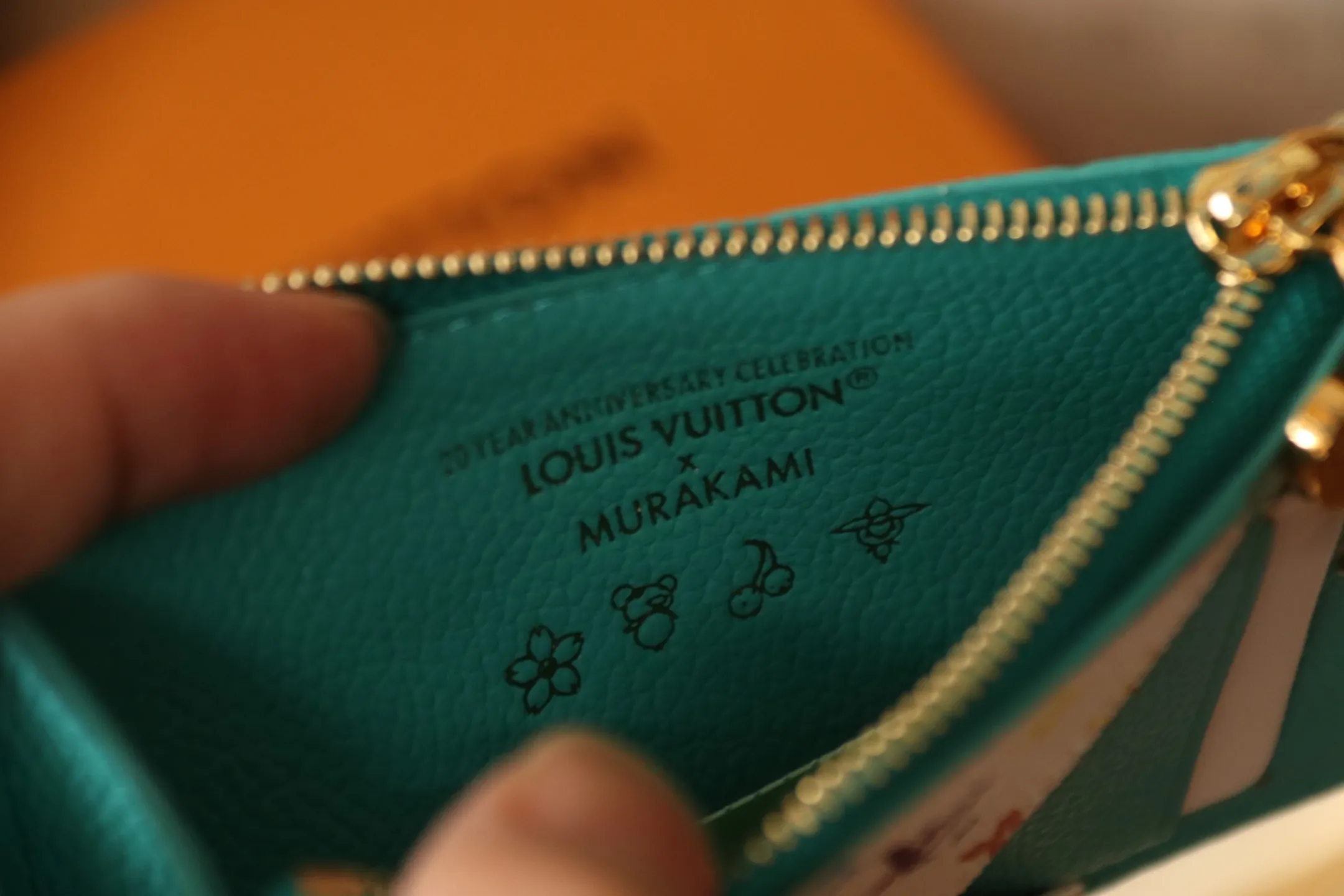【LV x TM Romy Card Holder】 💎P400 m14155 Rose m14171 Blue m13800 Green "LV × TM Porto Kurt Romy" appears in the "Louis Vuitton × Takashi Murakami" series that unfolds in a variety of categories. It features functional and playful expressions with fresh tones inspired by the rainbow colors unique to Japanese artists. The whole piece is finished with Monogram Amplant leather that adds a casual personality, and the bright Monogram multi-color canvas in the flat pocket stands out. The coin pocket opens and closes with a gold zipper and features a panda pull to symbolize the season.  Dimensions: 12 x 8 x 0.8 cm