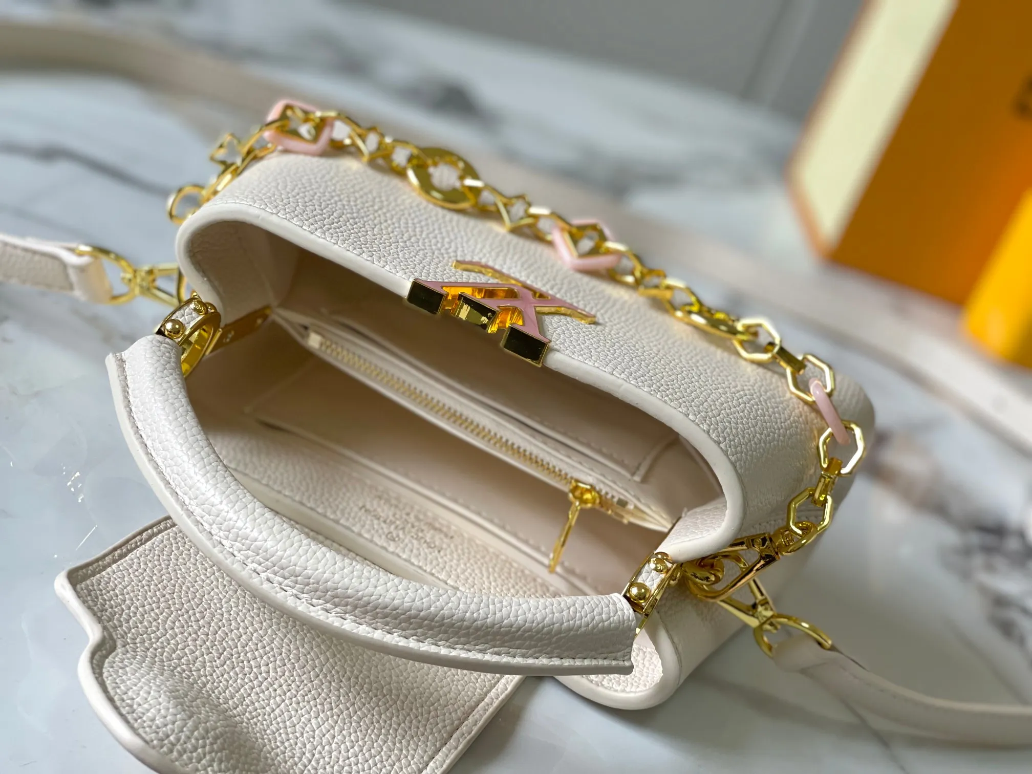 p460 [Guangzhou top quality original] M14393 white CapucinesEastWest mini handbag, with a decorative chain showing the inspiration of Monogram flowers. Taurillon cow leather creates an exquisite structure, and the LV letters interpret the colorful brushstrokes of the Puffygram jewelry series. The flap can be folded in or out, and the inner pocket can safely store valuables. Size:22×12×8cm