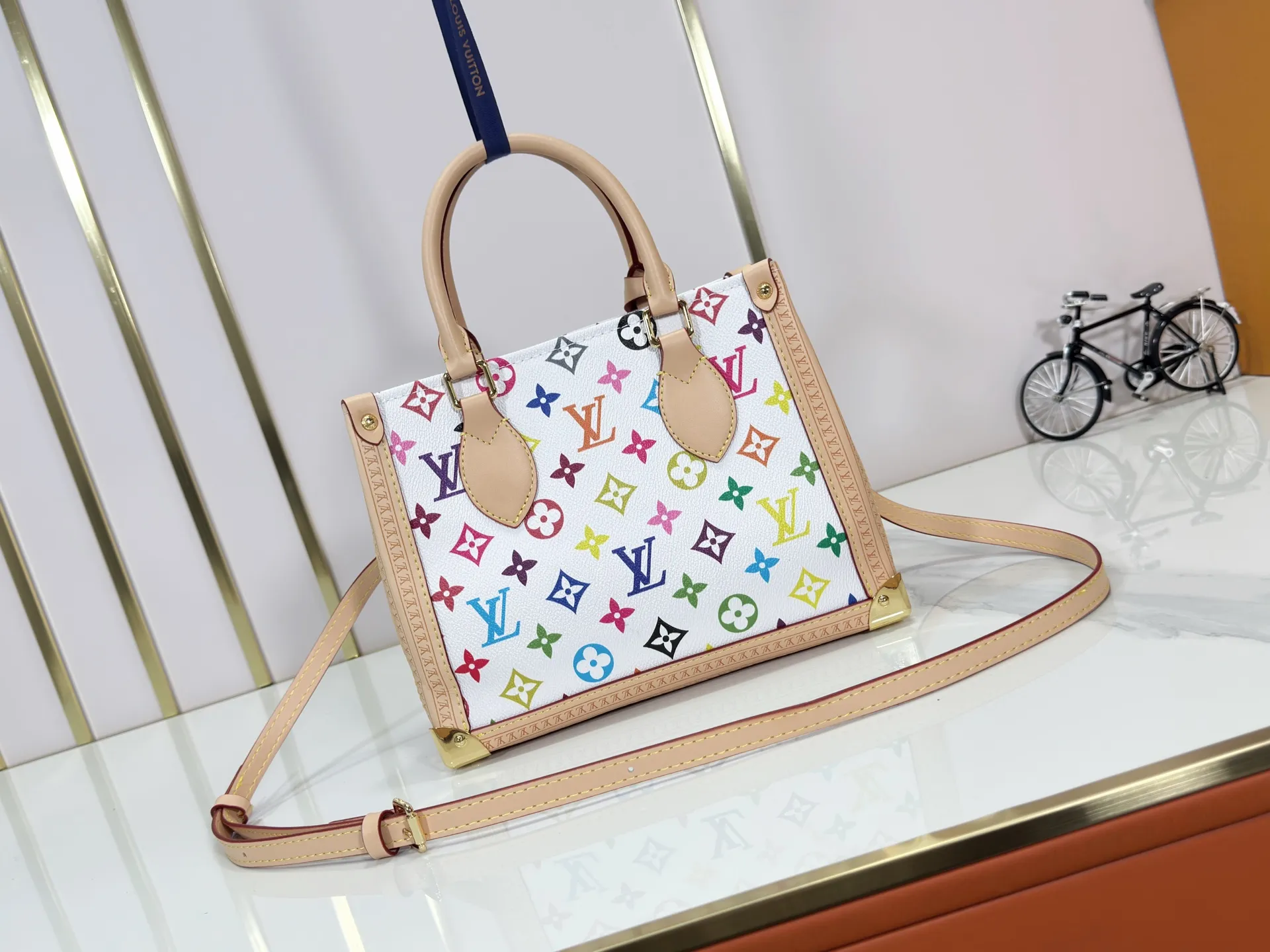 P300 upgraded original M13079 M45495 M45659 M44571 The Louis Vuitton x Murakami reissue series interprets the OnTheGo small handbag in a smart way. The colorful Monogram canvas body, cowhide leather trim and LV x TM key bag highlight the sophisticated style. The shiny corners recall the design of traditional Louis Vuitton luggage, and the shoulder strap and top handle allow for multiple carrying methods. Dimensions: 25.0 x 19.0 x 11.5 cm (length x height x width)