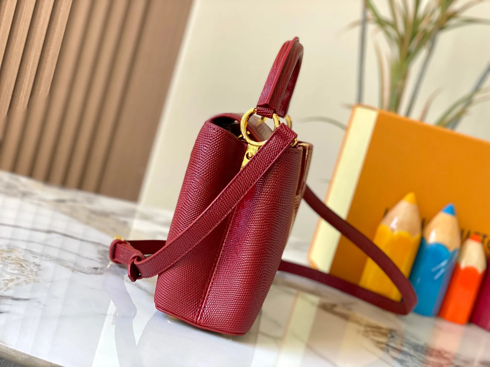 Top original P440 Guangzhou-made M99528 maroon lizard skin gold buckle CapucinesBB handbag exquisitely combines graceful lizard skin outer layer, delicate sheepskin lining and glossy metal parts. The iconic flip cover makes two styles fashionable. The LV logo can be read on the inside and Monogram flowers bloom on the outside. It can light up an eye-catching corner for evening occasions and add a personalized atmosphere to the wardrobe. Shine gorgeous style in day and night occasions.  Detailed features 27 x 18 x 9 cm (length x height x width)