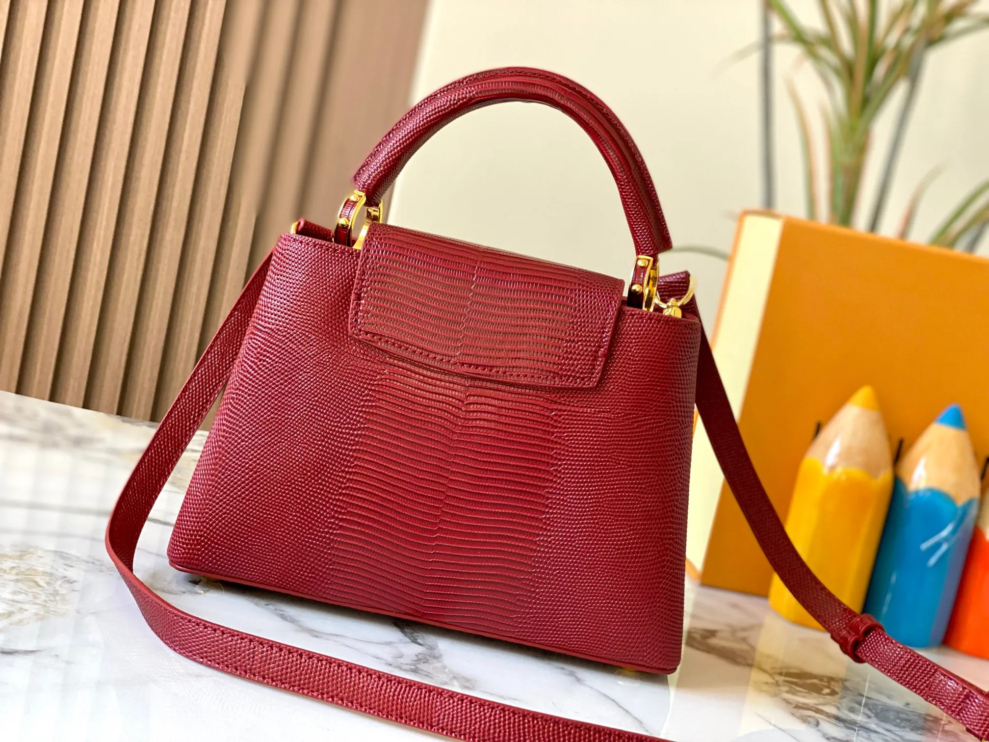 Top original P440 Guangzhou-made M99528 maroon lizard skin gold buckle CapucinesBB handbag exquisitely combines graceful lizard skin outer layer, delicate sheepskin lining and glossy metal parts. The iconic flip cover makes two styles fashionable. The LV logo can be read on the inside and Monogram flowers bloom on the outside. It can light up an eye-catching corner for evening occasions and add a personalized atmosphere to the wardrobe. Shine gorgeous style in day and night occasions.  Detailed features 27 x 18 x 9 cm (length x height x width)