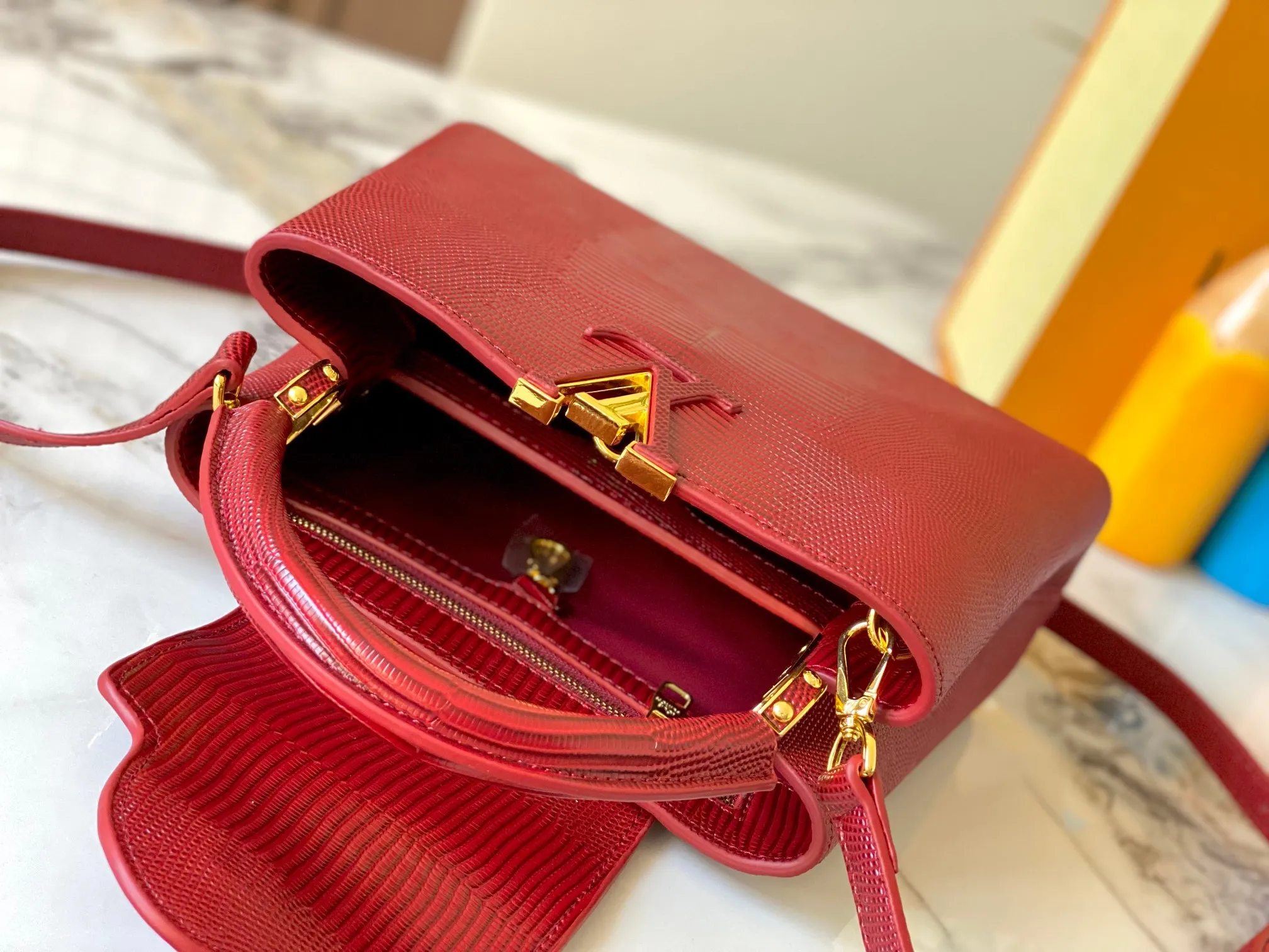 Top original P440 Guangzhou-made M99528 maroon lizard skin gold buckle CapucinesBB handbag exquisitely combines graceful lizard skin outer layer, delicate sheepskin lining and glossy metal parts. The iconic flip cover makes two styles fashionable. The LV logo can be read on the inside and Monogram flowers bloom on the outside. It can light up an eye-catching corner for evening occasions and add a personalized atmosphere to the wardrobe. Shine gorgeous style in day and night occasions.  Detailed features 27 x 18 x 9 cm (length x height x width)