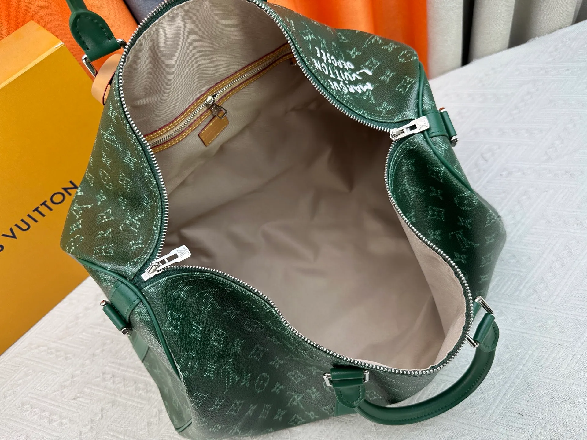 P340 Upgraded original M26864 M26865 M26866 This Keepall Bandoulière 50 travel bag is made of Monogram Heritage canvas dip-dyed in colorful colors, with cowhide trim, leather shoulder straps, removable leather nameplate and cotton lining. The Marque L.Vuitton Déposée logo pays homage to Louis Vuitton’s rich heritage.  29 x 23 x 50 cm (H x W x L) Monogram Heritage coated canvas Cow leather trim Textile lining Metal hardware Carry-on baggage dimensions Double zip closure Padlock Removable name tag Internal zip pocket Handles: Double handles