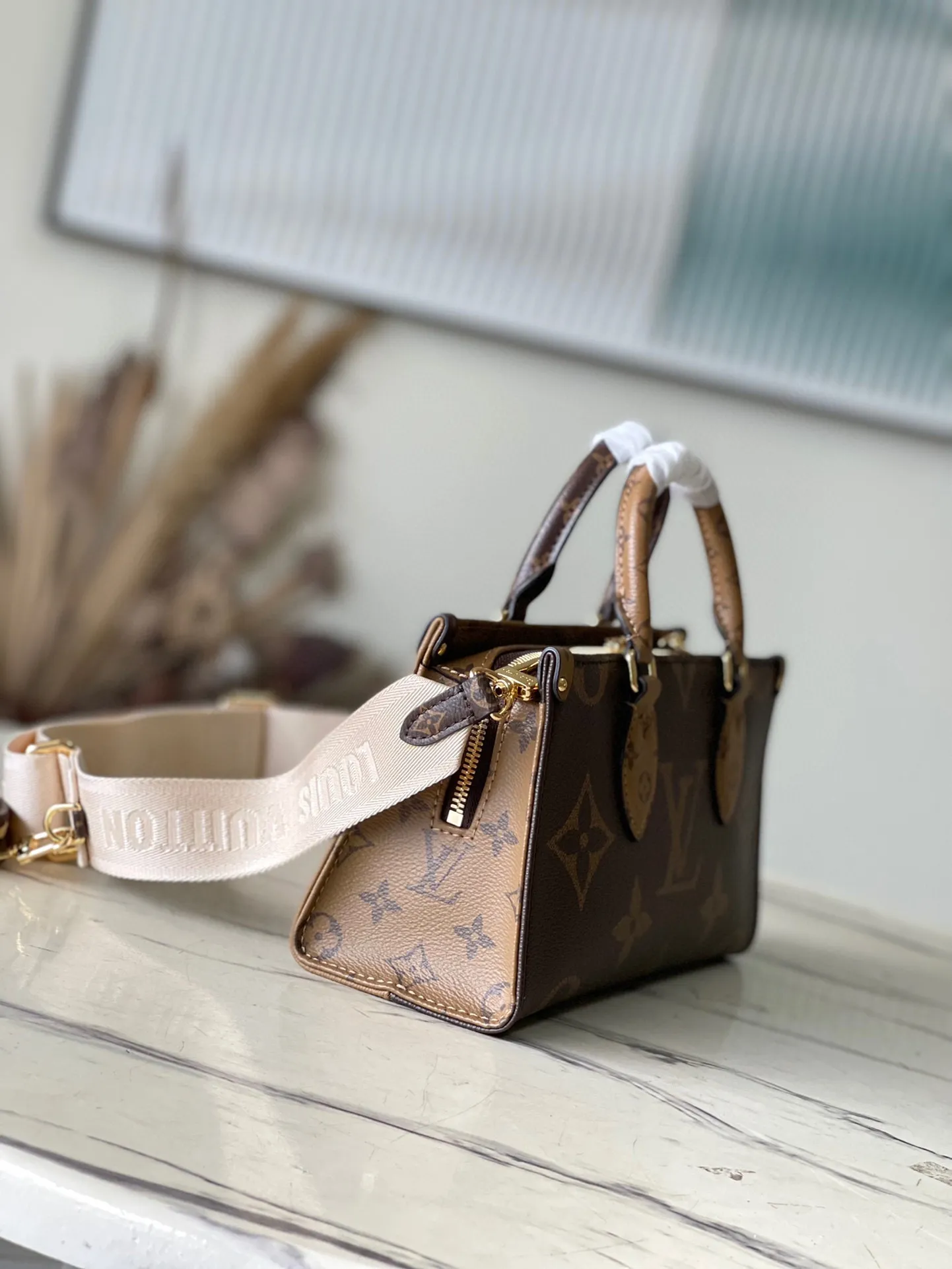 💰860 Top Original M46653 OnTheGo Tote Bag combines Giant Monogram and Monogram Reverse canvas to reinterpret the ample configuration of East West. The detachable round coin pouch is richly detailed, while the Toron top handle and detachable wide shoulder strap allow for multiple carrying options. Size: 25*13*10 cm