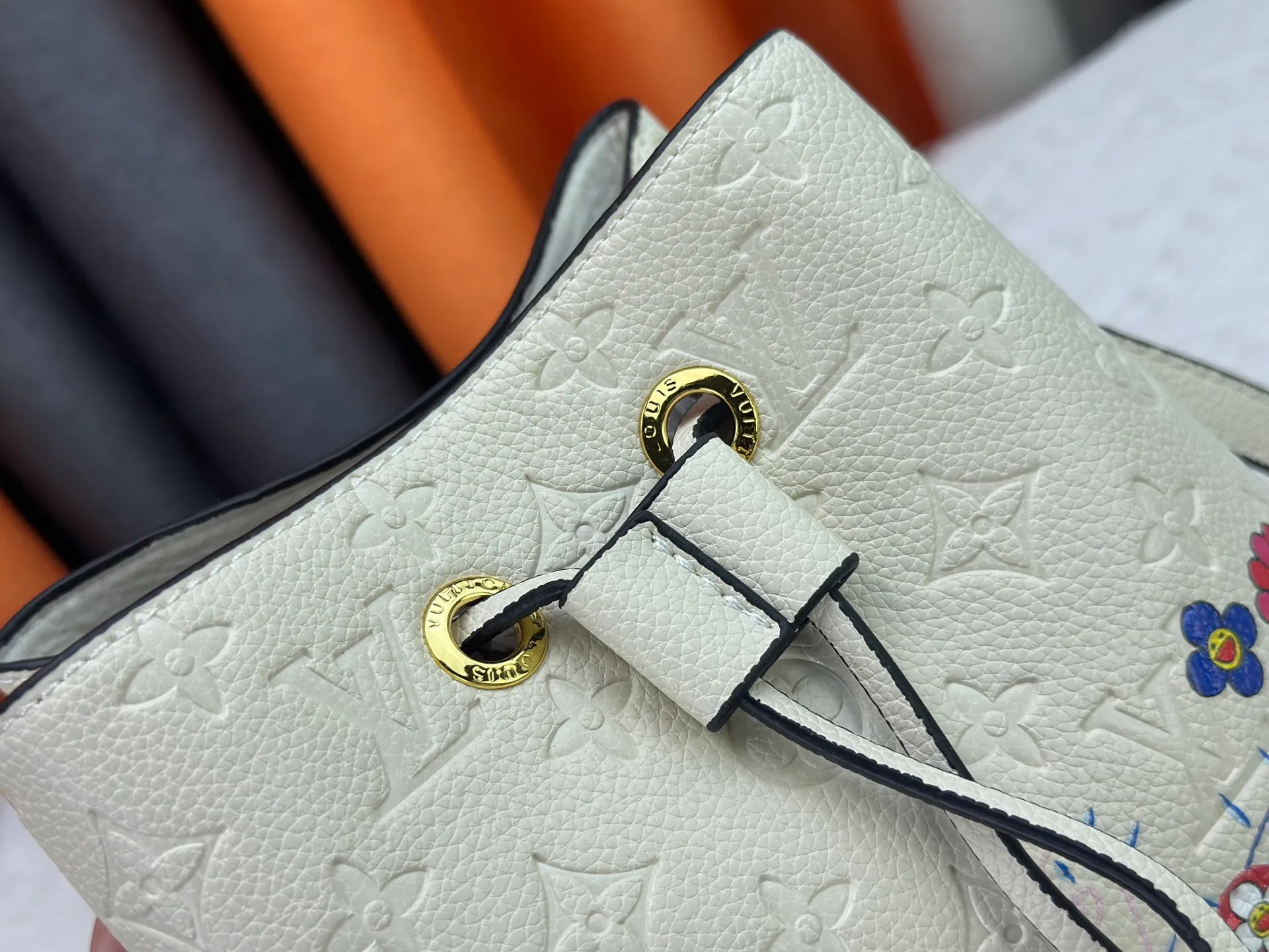 P240 M13676 M44021 This NeoNoe BB bucket bag comes from the Louis Vuitton × Murakami replica series, using Monogram Empreinte leather to convey a fresh breath and smart style. Murakami's signature Cherry Blossom pattern appears on the Monogram embossed surface, and the same floral element is transformed into a slide buckle to tighten the drawstring. Size: 20x20x13cm