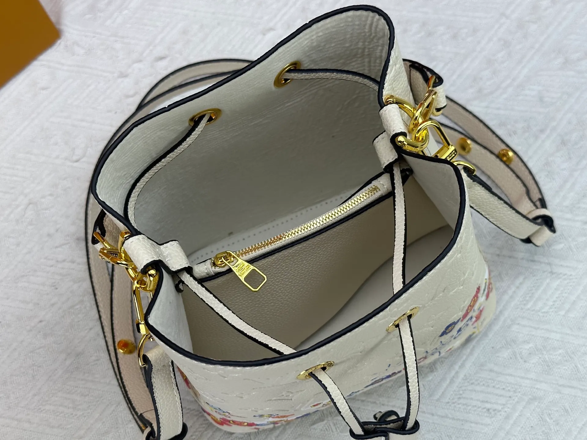P240 M13676 M44021 This NeoNoe BB bucket bag comes from the Louis Vuitton × Murakami replica series, using Monogram Empreinte leather to convey a fresh breath and smart style. Murakami's signature Cherry Blossom pattern appears on the Monogram embossed surface, and the same floral element is transformed into a slide buckle to tighten the drawstring. Size: 20x20x13cm