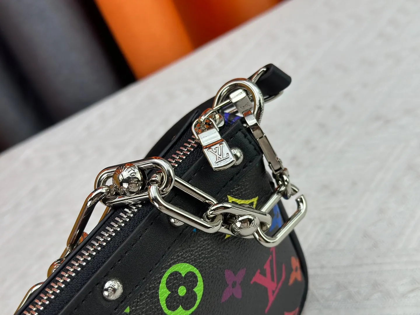 P220 M13404 M13663 Black color White color This Pochette Accessoires handbag is made of coated canvas, with colorful Monogram patterns to interpret the smart style of the Louis Vuitton × Murakami cross-border collaboration series. Calf leather trim and dazzling hardware add to the sophisticated details, while the detachable shoulder strap and chain provide flexible carry. Size: 22x13x4cm