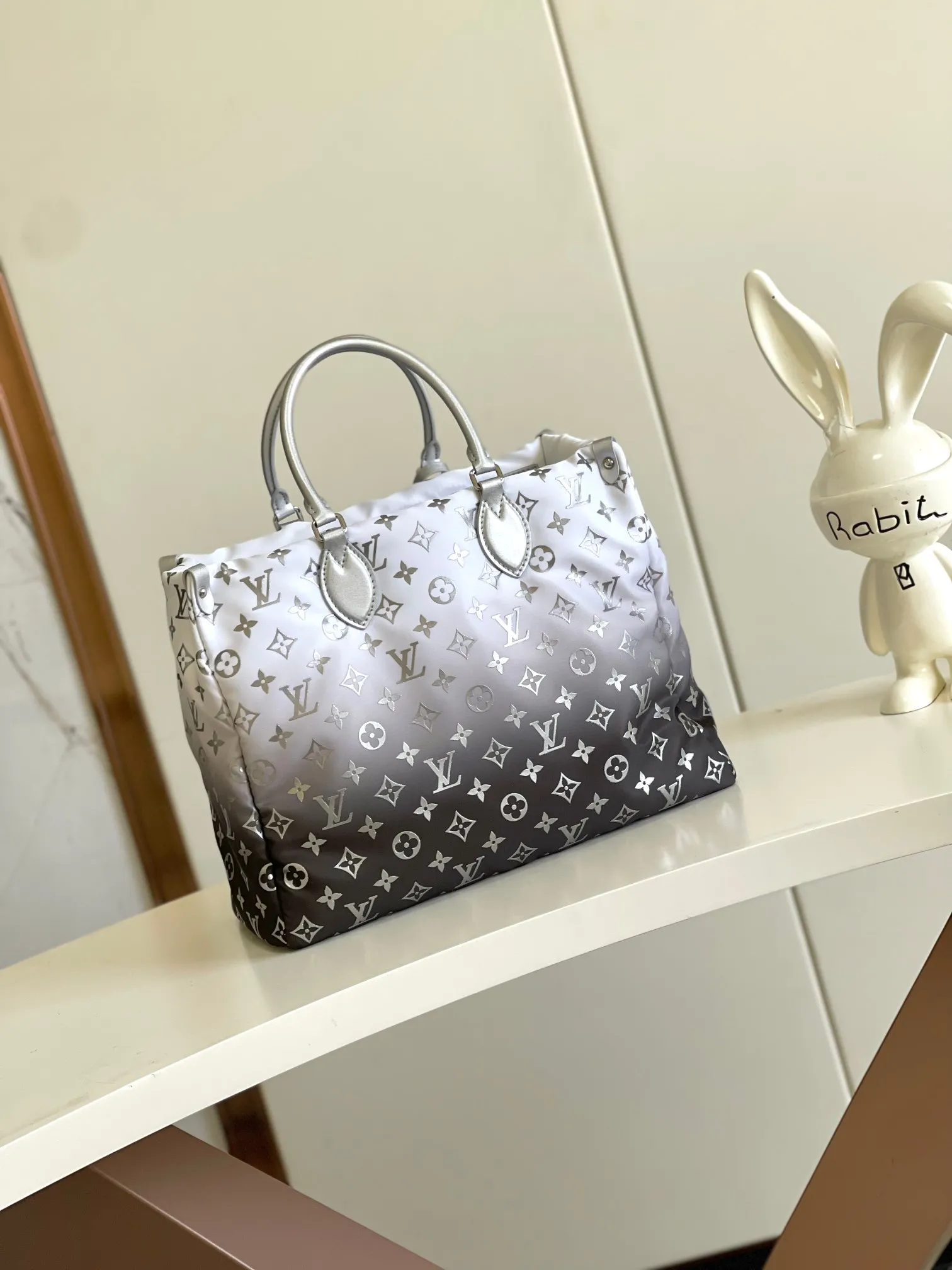💰1180 top original single dynamic chip M11847 silver This OnTheGo medium handbag is from the LV Snow series. It uses new Monogram nylon to display a gradient effect silk screen pattern, with bright metal parts and floral decoration, making it a good choice for mountaineering and urban travel. The spacious design can accommodate a 13-inch laptop, and you can switch the carrying mode at will.  27 cm