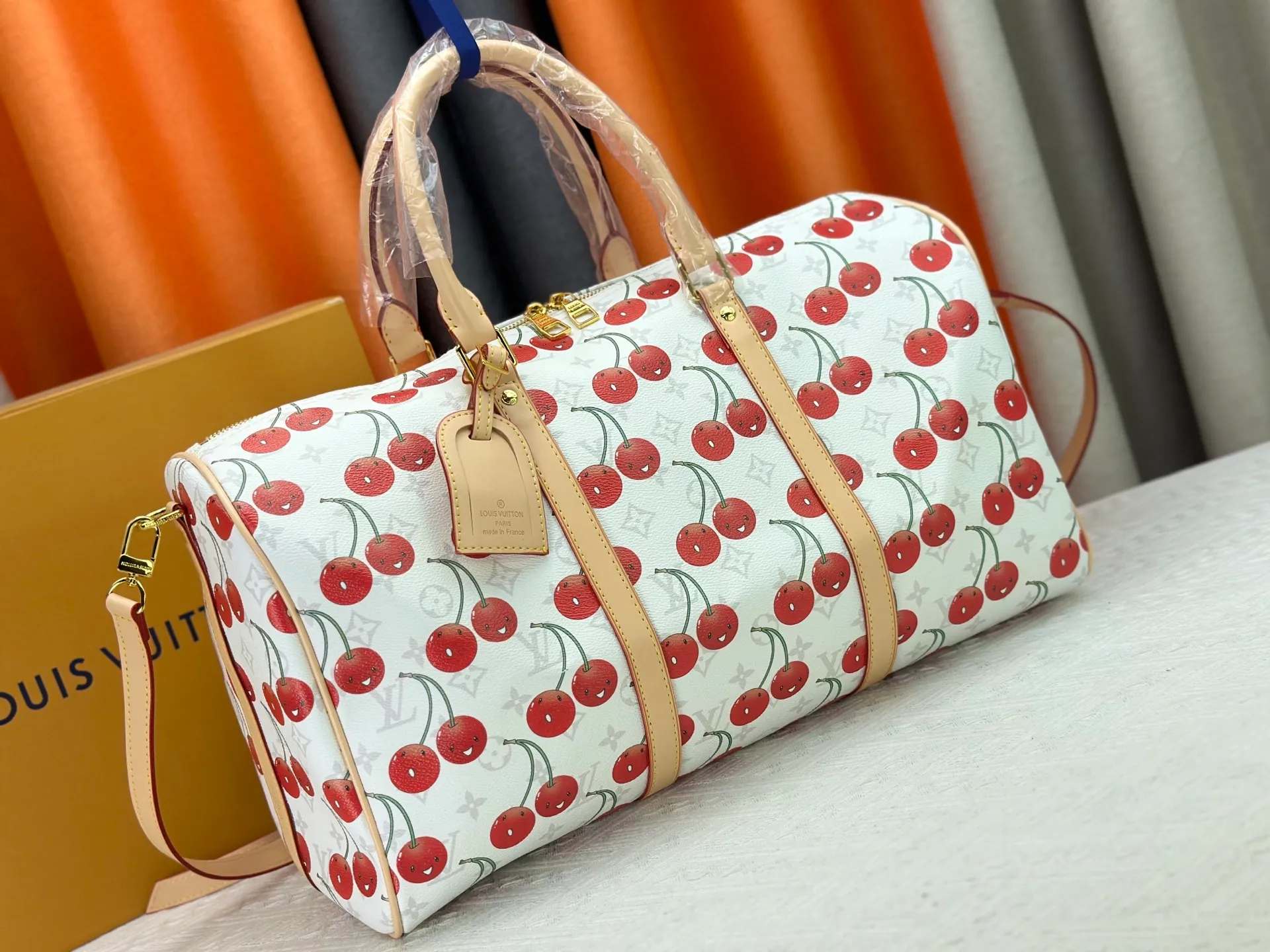 230 M13764 M41416 🍒Keepall Bandoulière 45 travel bag has a new look with the Louis Vuitton x Takashi Murakami replica series. Classic Monogram canvas features a patchwork pattern of sweet cherries and a bold lining that reflects the playful aesthetic of renowned Japanese artist Takashi Murakami. Side straps, top handles and adjustable shoulder straps reveal the natural color of the leather, while dazzling hardware completes the look.  27 x 20 x 45 cm (H x W x L) Carry-on dimensions Monogram coated canvas Cow leather trim Textile lining Metal hardware Double zipper closure Internal zip pocket Padlock Designer tag, hot stampable Shoulder strap: removable, adjustable Half-length strap: 36.0 cm Half-length strap adjustable to: 50.0 cm Handle: Double handle