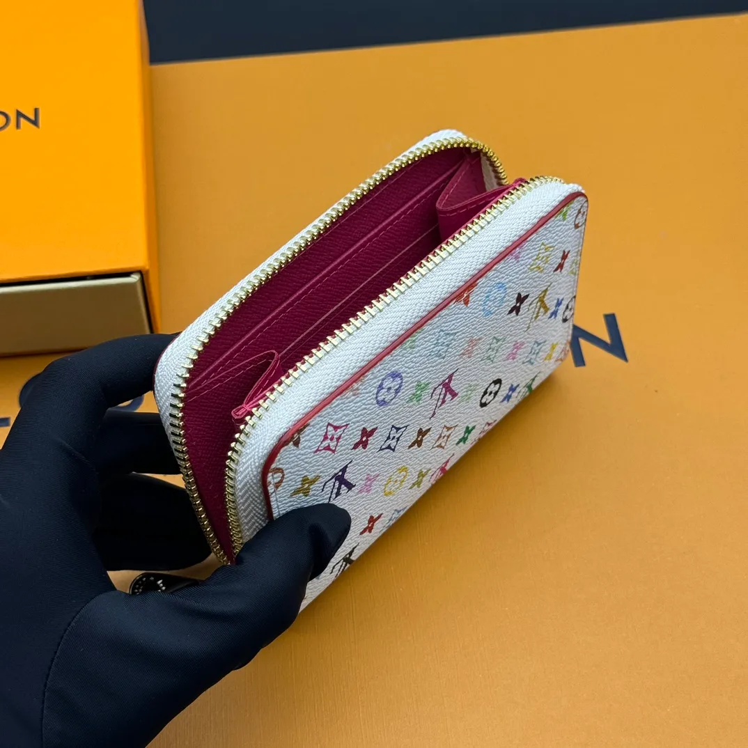 💰110 💎Premium Original 🇫🇷 LV x TM Zippy Coin Purse Black (Three Colors - Takashi Murakami) As part of the Louis Vuitton x Murakami collection reissue, the timeless Zippy Coin Purse is practical and playful, upgraded for this season. It's made from Monogram coated canvas in a cheerful rainbow of hues, in keeping with the Japanese artist's signature pop palette. The interior is secured with a silver zipper and is divided into multiple compartments for coins, banknotes and cards. Model: M13409 Dimensions: 11 x 8.5 x 2 cm.