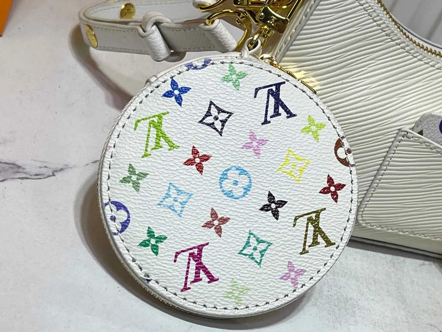 Batch 240💰M13099 This Marellini handbag is made of rich-textured Epi leather to create a delicate structure with ample space to store daily necessities such as smartphones. The round coin purse and mirror are both made of the colorful Monogram canvas from the Louis Vuitton x Takashi Murakami collaboration series, and are fixed to the bag body with a rough metal chain. Size: 19x13.5x6.5cm