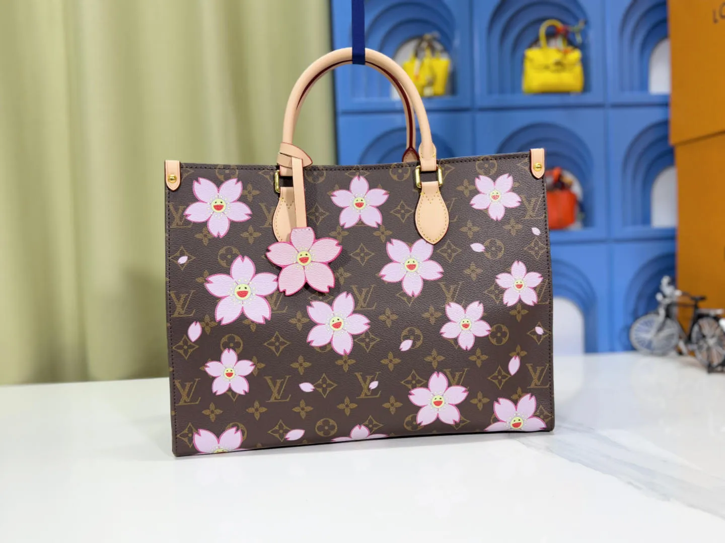 P260 M45039 M13668!🔥Lv&Takashi Murakami Sakura🌸OnTheGo new version The legendary ONTHEGO handbag: always able to meet your various needs for handbags. It has a large capacity but is not bulky. It is stiff and soft to the touch, making it suitable for home and travel. Tighten the side ties and it instantly transforms into a stylish urban handbag. Loosen the straps and it transforms into a chic and practical handbag. The slender leather handle can be carried over the shoulder or between the arms. The model shown here is made of Damier Azur canvas. Size: 35x27x14cm