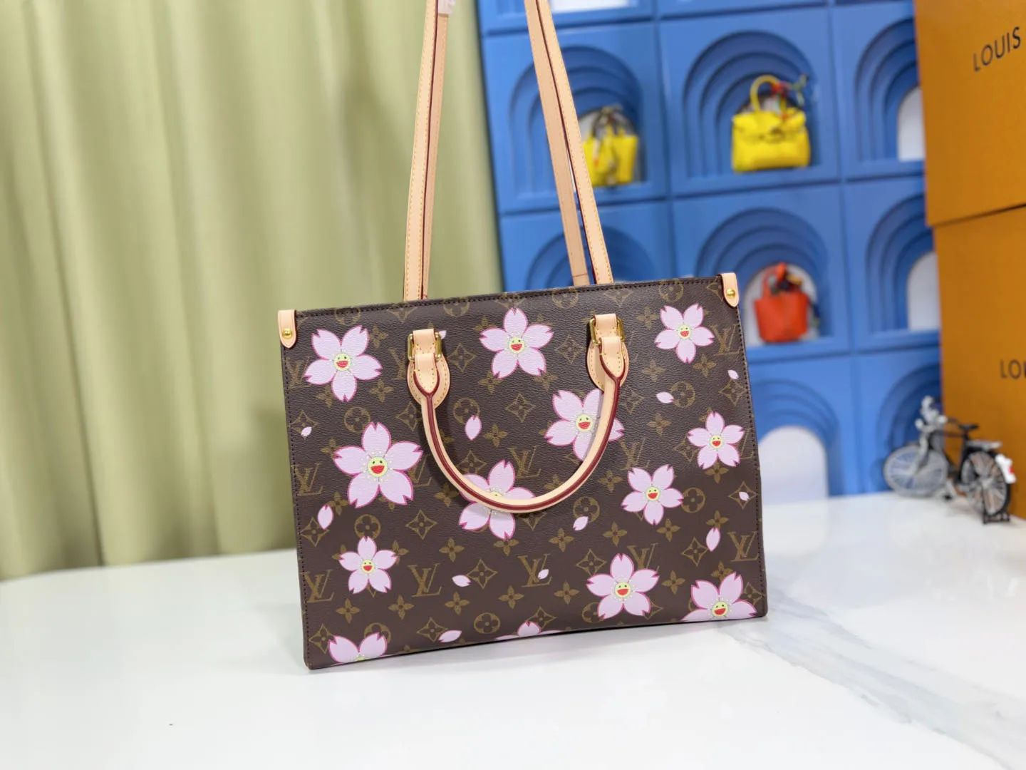 P260 M45039 M13668!🔥Lv&Takashi Murakami Sakura🌸OnTheGo new version The legendary ONTHEGO handbag: always able to meet your various needs for handbags. It has a large capacity but is not bulky. It is stiff and soft to the touch, making it suitable for home and travel. Tighten the side ties and it instantly transforms into a stylish urban handbag. Loosen the straps and it transforms into a chic and practical handbag. The slender leather handle can be carried over the shoulder or between the arms. The model shown here is made of Damier Azur canvas. Size: 35x27x14cm