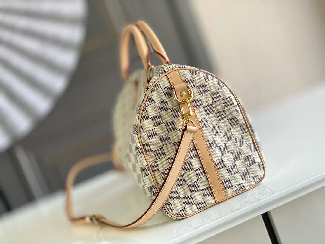 💰800 Top original N41373 SPEEDY 30 handbag (with shoulder strap) Every feature of this Speedy handbag is classic: leather handle, Damier Azur canvas. No wonder it has become a particularly popular bag in the world. Originally designed for travelers in 1930 (its name pays homage to the high-speed traffic of the time), the Speedy 30, with its cross-body strap, has become the ideal urban bag - soft, lightweight and classic. Detailed Features 30 x 21 x 17 cm (Length x Height x Width) Shiny gold-tone brass hardware and padlock Lockable double zipper closure Internal pocket D-ring for keys and accessories Soft fabric lining Shoulder strap: removable, adjustable Strap half-length: 48.0 cm Strap half-length adjustable to: 55.0 cm Handle: Double handle