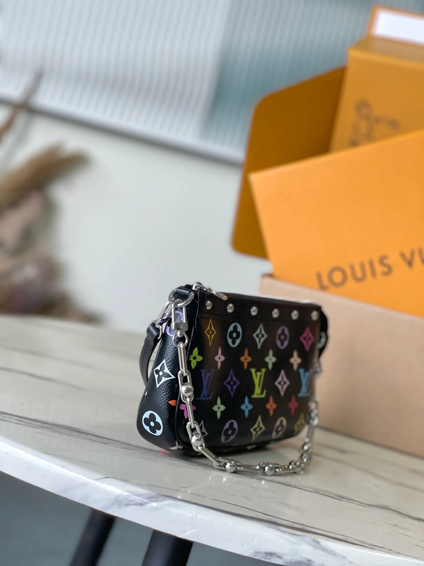 💰880 Top Original Order M13663 Black Color This Pochette Accessoires handbag is made of coated canvas and uses colorful Monogram patterns to interpret the smart style of the Louis Vuitton x Murakami cross-border collaboration series. Calf leather trim and dazzling hardware add to the sophisticated details, while the detachable shoulder strap and chain allow for flexible carry. 13 x 4 x 22 cm (height x width x length)