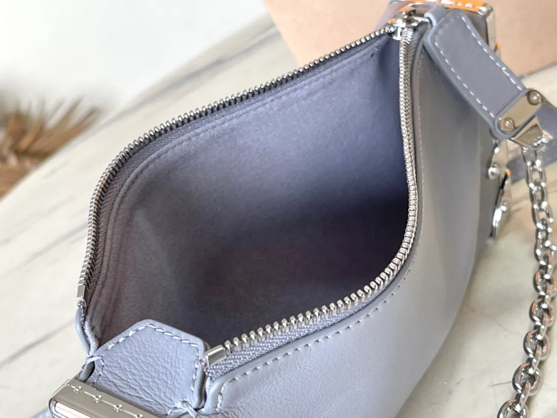 💰1420 (first-grain leather) Top-quality original order M12596 This Slim Trunk handbag draws inspiration from Louis Vuitton’s traditional hard trunk. The soft cow leather is integrated with rivet frames and metal S-lock locks, highlighting the avant-garde rock style. The shiny chain and adjustable leather shoulder strap are both detachable, providing a variety of carrying options. Dimensions: 23 × 12 × 4 cm