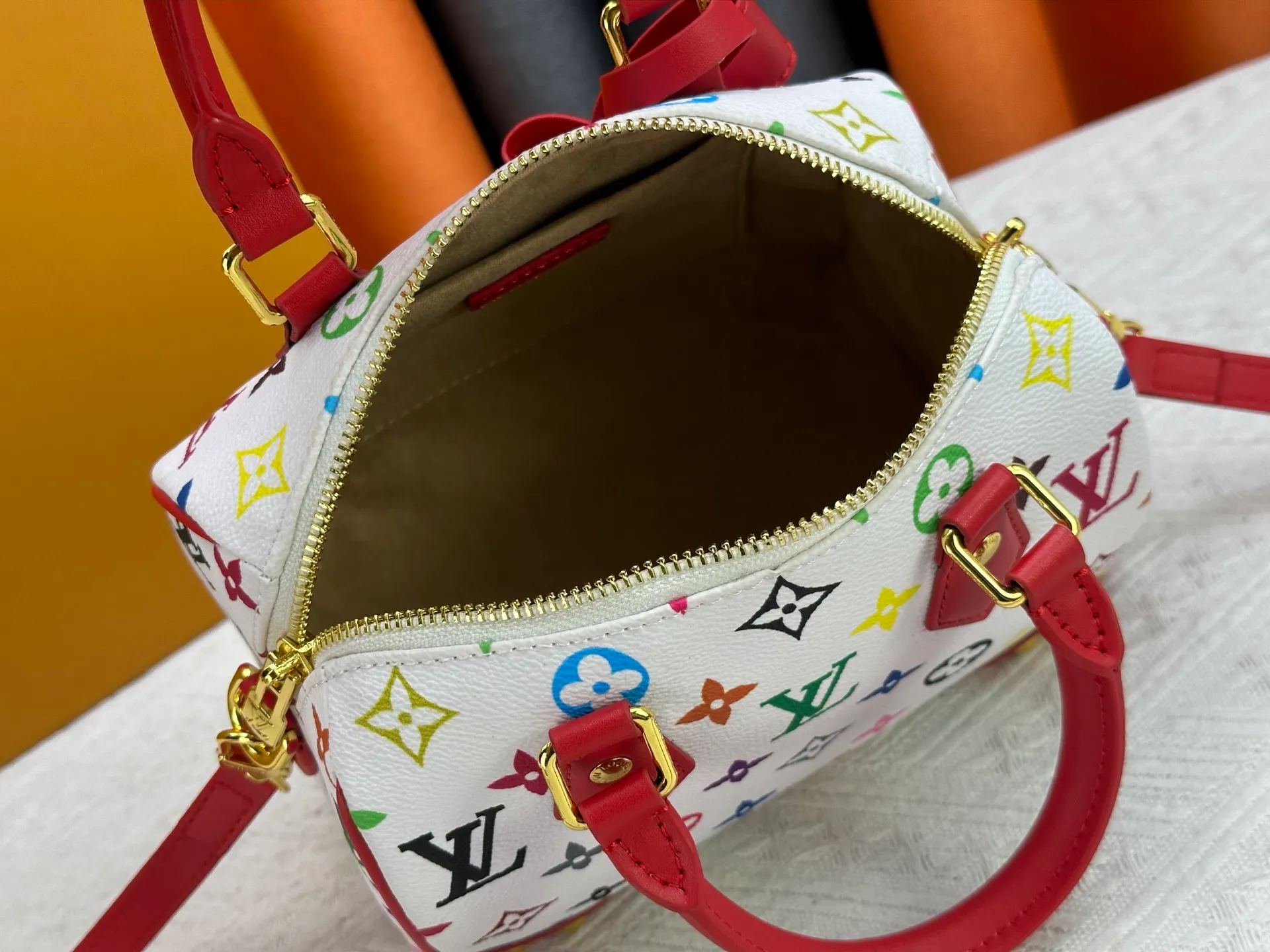 P260 upgraded original M58953 M46234 M46222 Speedy Bandoulière 20 handbag is made of soft coated canvas, and the full-length Monogram pattern is traced in colorful rainbow tones, highlighting the smart style of the Louis Vuitton x Murakami reissue series. The Toron handle and detachable shoulder strap are constructed of cow leather, the metal corners recall classic luggage elements, and the bow-shaped key bag and padlock add brand touches. Dimensions: 20.5 x 13.5 x 12.0 cm (length x height x width)