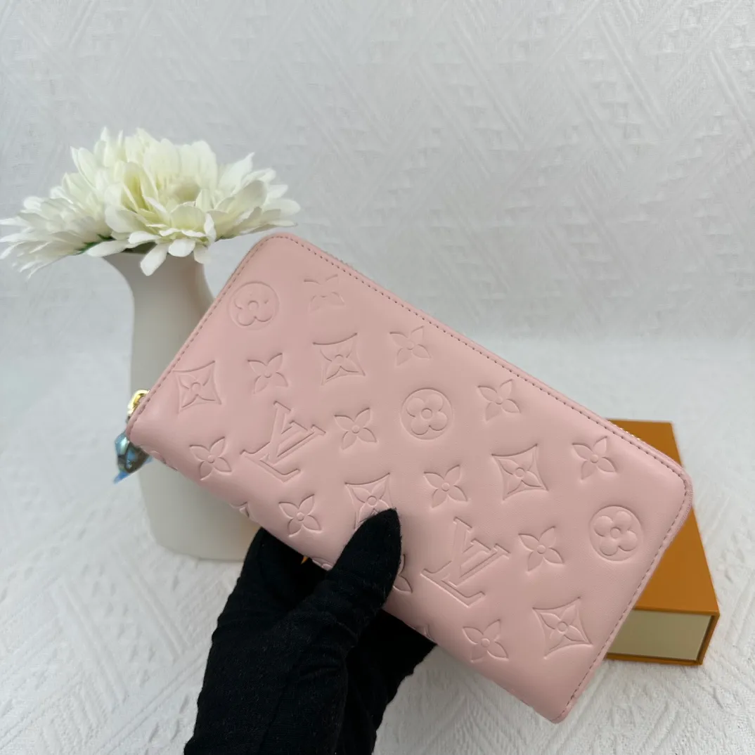 P130 M81511 Pink Stitched with padded Monogram embossed lambskin, it complements the Coussin leather boutique collection. Beautifully designed with a gold-tone zipper embossed with the LV Circle signature pull, the interior of the all-in-one wallet is packed with practical features, including three large compartments, a coin compartment and 12 business card slots. Dimensions: 19.5 x 10.5 x 2.5 cm