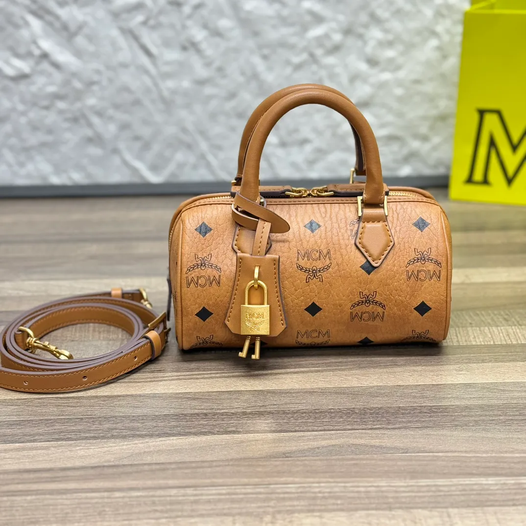 (Original order 💰520)𝗠𝗖𝗠 𝗘𝗹𝗹𝗮 𝗩𝗶𝘀𝗲𝘁𝗼𝘀🆕New Brown Mini#Boston Bag New Batch 520·CP Exclusive®️Brown Presbyopia Full Print This mini Ella Boston bag was born in the golden age of Munich and is a daily shoulder bag. The design of the leather tag and engraved logo metal padlock is inspired by the brand’s travel tradition and is directly taken from the brand’s classic suitcases.  Number: 1058 Mini Size: 18*9*9.5cm Shoulder strap: Adjustable 97-113cm Handle: Drop length 8cm Zipper: Two-way fully closed zipper Comes with airplane case