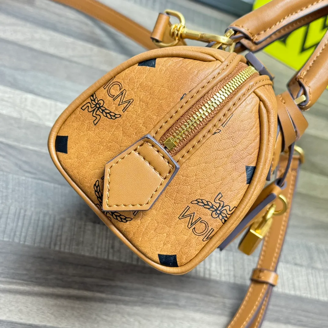 (Original order 💰520)𝗠𝗖𝗠 𝗘𝗹𝗹𝗮 𝗩𝗶𝘀𝗲𝘁𝗼𝘀🆕New Brown Mini#Boston Bag New Batch 520·CP Exclusive®️Brown Presbyopia Full Print This mini Ella Boston bag was born in the golden age of Munich and is a daily shoulder bag. The design of the leather tag and engraved logo metal padlock is inspired by the brand’s travel tradition and is directly taken from the brand’s classic suitcases.  Number: 1058 Mini Size: 18*9*9.5cm Shoulder strap: Adjustable 97-113cm Handle: Drop length 8cm Zipper: Two-way fully closed zipper Comes with airplane case