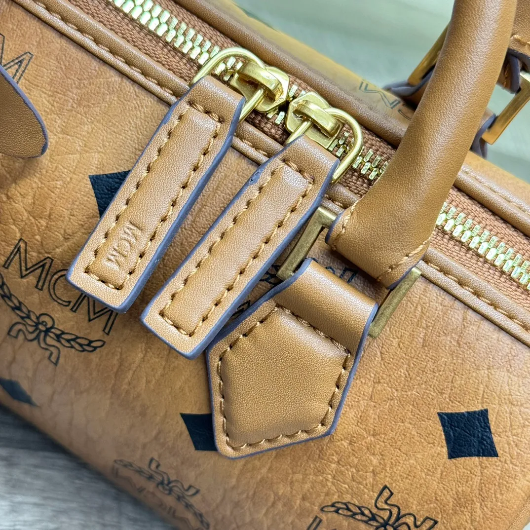 (Original order 💰520)𝗠𝗖𝗠 𝗘𝗹𝗹𝗮 𝗩𝗶𝘀𝗲𝘁𝗼𝘀🆕New Brown Mini#Boston Bag New Batch 520·CP Exclusive®️Brown Presbyopia Full Print This mini Ella Boston bag was born in the golden age of Munich and is a daily shoulder bag. The design of the leather tag and engraved logo metal padlock is inspired by the brand’s travel tradition and is directly taken from the brand’s classic suitcases.  Number: 1058 Mini Size: 18*9*9.5cm Shoulder strap: Adjustable 97-113cm Handle: Drop length 8cm Zipper: Two-way fully closed zipper Comes with airplane case
