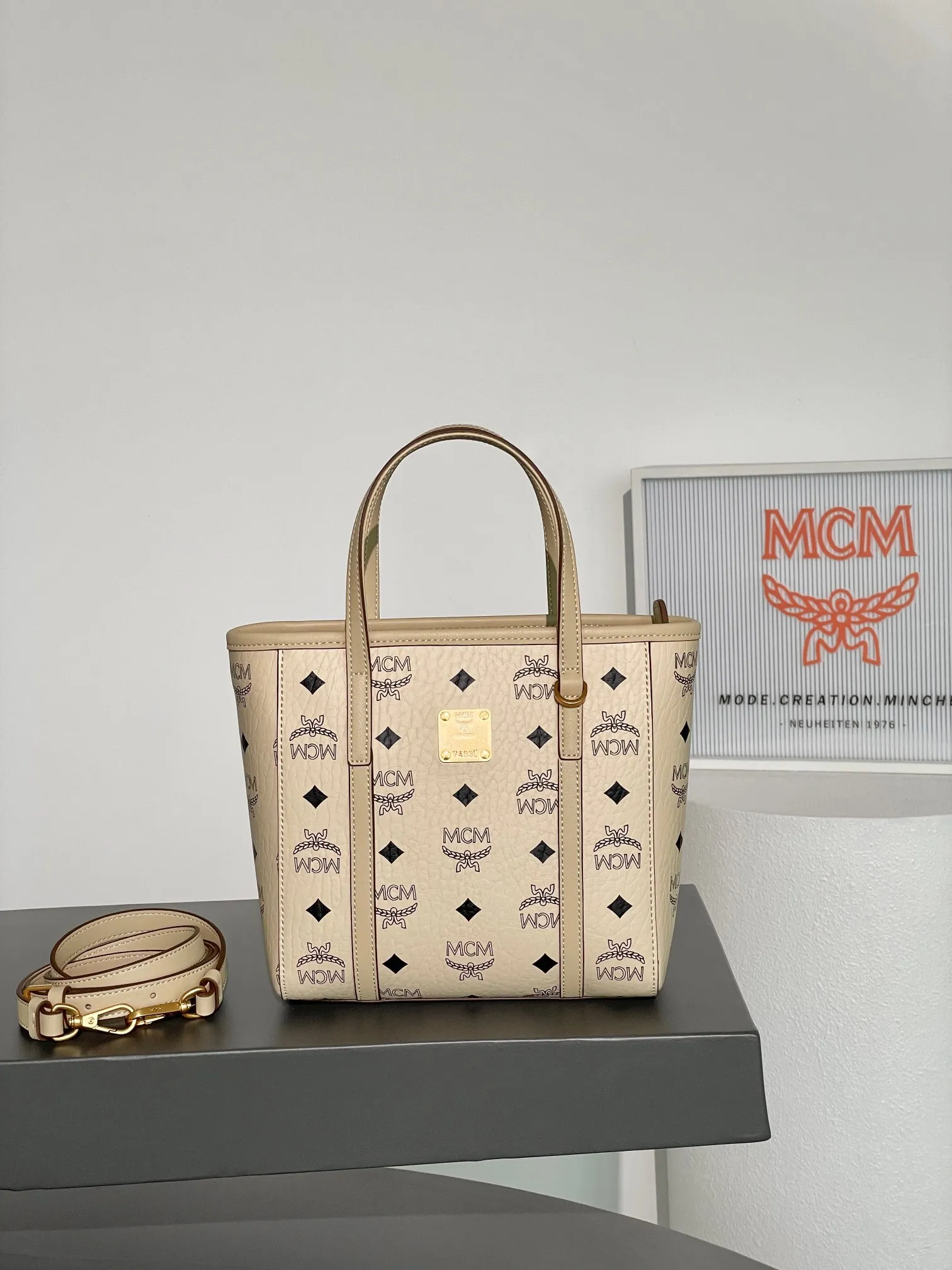 𝗠𝗖𝗠 𝗔𝗿𝗲𝗻 𝗩𝗶𝘀𝗲𝘁𝗼𝘀 𝗠𝗶𝗻𝗶 🆕New rice and cabbage basket 💰520 👏New colors, exclusive®️old flower all over print Mini Aren shopper bag in signature Visetos and trimmed in Nappa leather. The bag features a geometric design that is both unique and practical. The bag is lined in luxurious cotton canvas and features a geometric print inspired by the brand's urban spirit. The top zipper closure ensures the safety of the belongings inside. Paired with a shoulder strap, it can be carried hands-free and has unparalleled versatility. Size: 19*9.5*18.5cm Shoulder strap: 98-114cm/removable Handle: drop length 10cm Opening and closing: zipper opening Color: off-white/Beige▫️ 💰520 comes with gift box