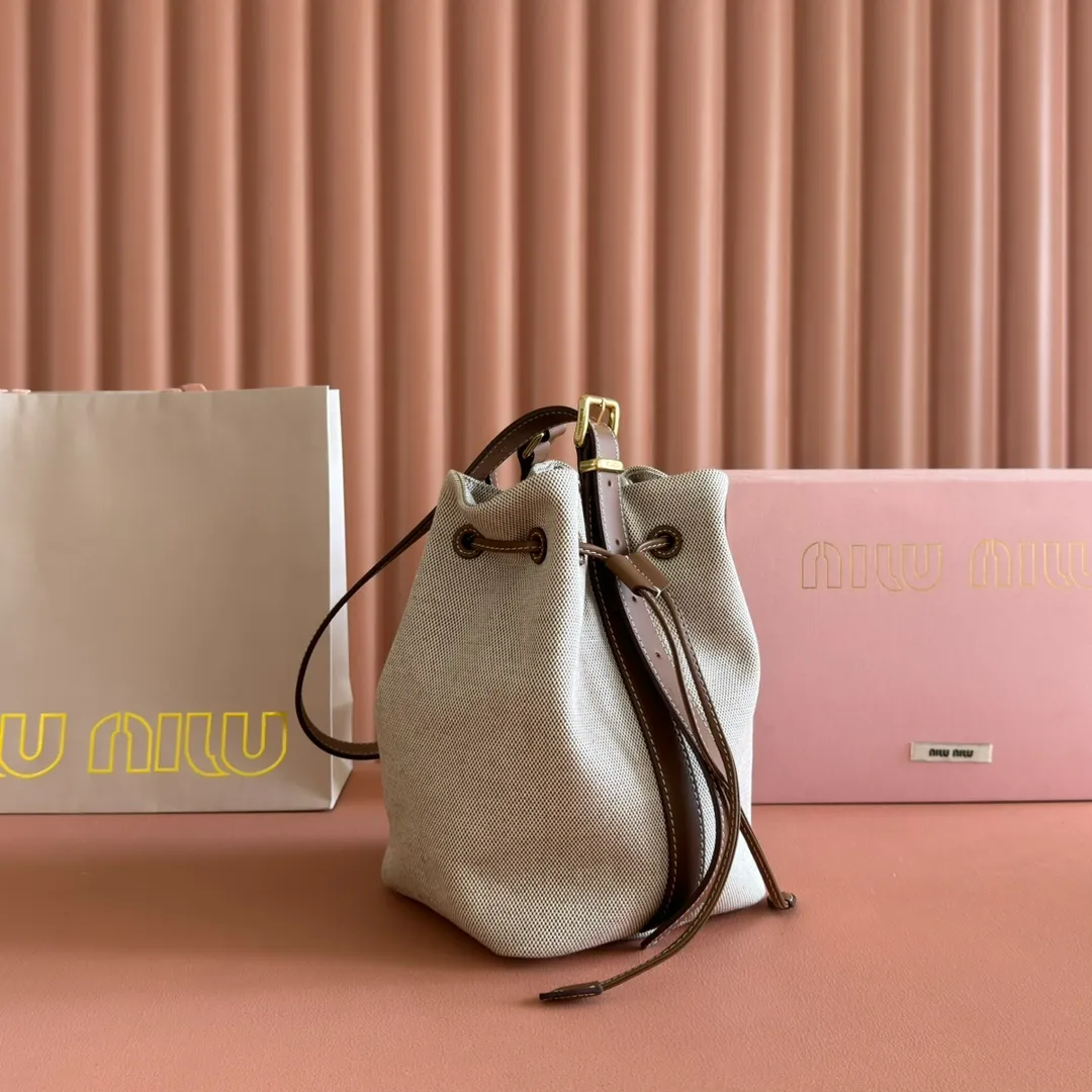 p1300💋💋💋【Full set of packaging at the counter】5BE089 Canvas Bucket Bag This canvas and leather bucket bag from Miu family is intertwined with contrasting materials and colors, highlighting its unique design features. The letter logo adds a unique personality to the design of this bag. Adjustable leather handles Gold-plated hardware Leather letter logo on front Leather drawstring closure Linen fabric lining Model: 5BE090 Dimensions: Height 16cm Width 22.5cm Length 14cm