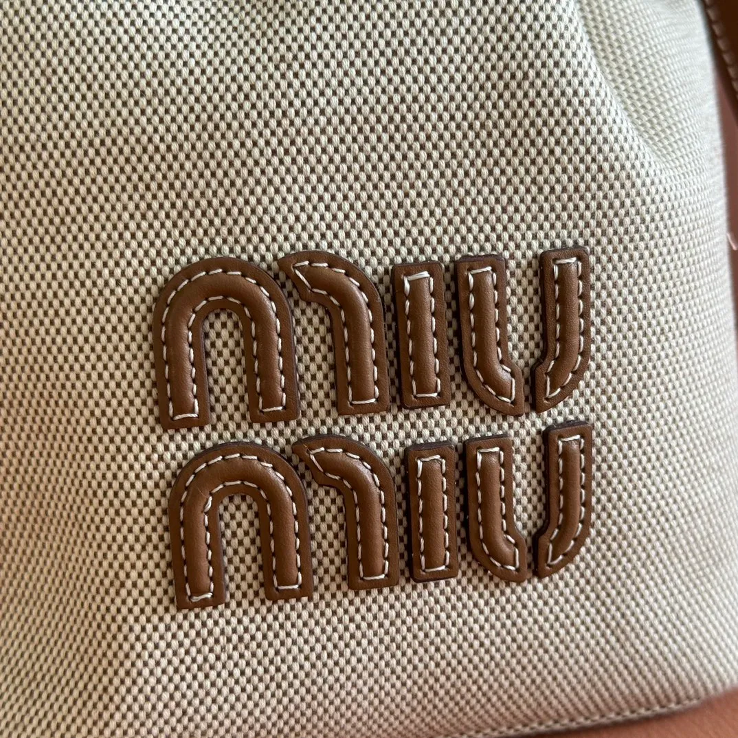 p1300💋💋💋【Full set of packaging at the counter】5BE089 Canvas Bucket Bag This canvas and leather bucket bag from Miu family is intertwined with contrasting materials and colors, highlighting its unique design features. The letter logo adds a unique personality to the design of this bag. Adjustable leather handles Gold-plated hardware Leather letter logo on front Leather drawstring closure Linen fabric lining Model: 5BE090 Dimensions: Height 16cm Width 22.5cm Length 14cm