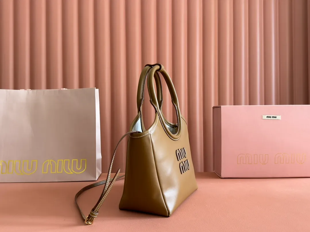 p1560. 💋💋💋【Full set of packaging at the counter】MIU’s new IVY handbag. Simple lines, urban style and high-quality leather are the key words of this new IVY handbag. It adopts an exquisite design and is embellished with letter logo, highlighting the classic style. Detachable and adjustable shoulder strap. Gold-tone hardware. Lettering logo on front, fabric lining, double zip pockets. Model: 5BA284 cognac color Size: 22*12*23.5cm