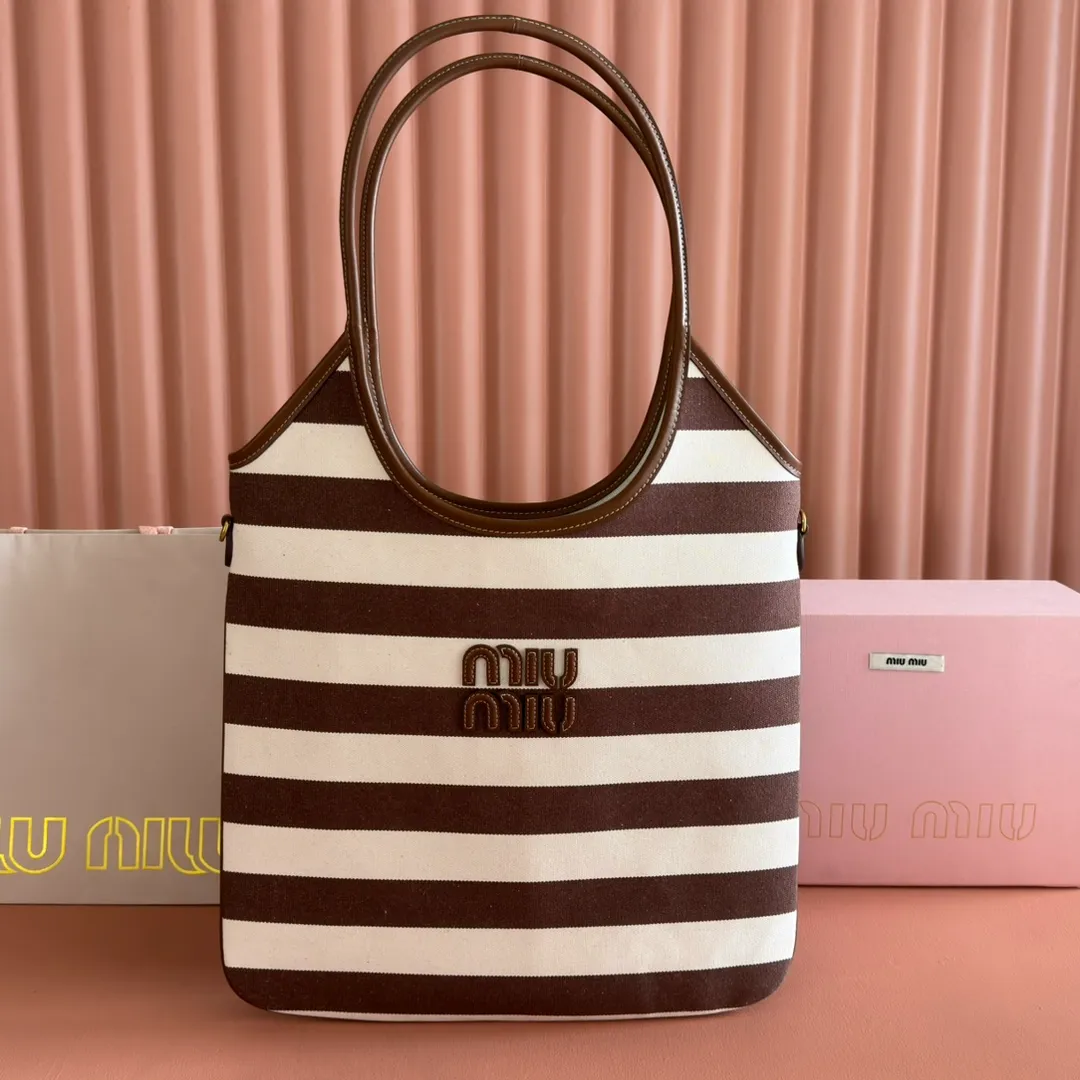 p1300. 💋💋💋【Full set of packages at the counter】𝗠𝗜𝗨𝗠𝗜𝗨 𝗙𝗪𝟮𝟱 𝗡𝗲𝘄 𝗮𝗿𝗿𝗶𝘃𝗮𝗹!      When striped canvas meets hobo's lazy gene, it grabs the first wave in autumn and winter. The relaxed feeling of commuting is directly capped. Classic blue and white nautical striped canvas × Italian calfskin piping. Flexible bag body hangs naturally. Tote capacity + Hobo's lazy feeling two-in-one. It looked like it was 𝗷𝗮𝗰𝗸𝗲𝘁 canvas, but when I touched the edge of the leather, I realized it was 𝗹𝘂𝘅𝘂𝗿𝘆!   The Ju Neng suit still hasn’t collapsed! 𝗵𝗼𝗯𝗼Bag shape looks slim 𝟭𝟬𝟬% 5BG231 stripes Size: 35×40cm