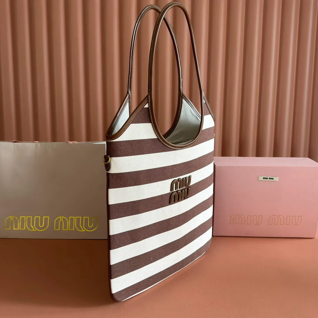 p1300. 💋💋💋【Full set of packages at the counter】𝗠𝗜𝗨𝗠𝗜𝗨 𝗙𝗪𝟮𝟱 𝗡𝗲𝘄 𝗮𝗿𝗿𝗶𝘃𝗮𝗹!      When striped canvas meets hobo's lazy gene, it grabs the first wave in autumn and winter. The relaxed feeling of commuting is directly capped. Classic blue and white nautical striped canvas × Italian calfskin piping. Flexible bag body hangs naturally. Tote capacity + Hobo's lazy feeling two-in-one. It looked like it was 𝗷𝗮𝗰𝗸𝗲𝘁 canvas, but when I touched the edge of the leather, I realized it was 𝗹𝘂𝘅𝘂𝗿𝘆!   The Ju Neng suit still hasn’t collapsed! 𝗵𝗼𝗯𝗼Bag shape looks slim 𝟭𝟬𝟬% 5BG231 stripes Size: 35×40cm