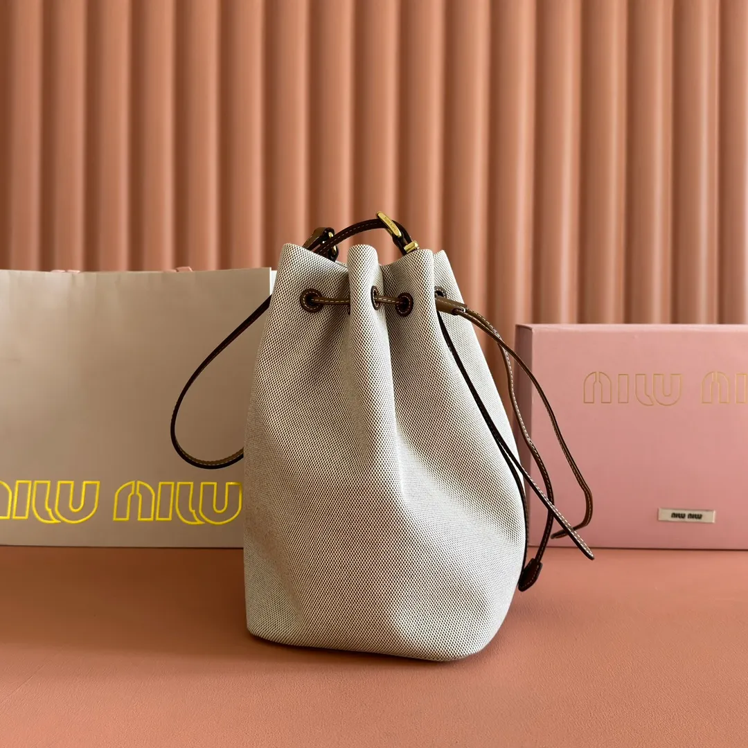 p1400💋💋💋【Full set of counter packaging】5BE089 Canvas Bucket Bag This canvas and leather bucket bag from Miu family is intertwined with contrasting materials and colors, highlighting its unique design features. The letter logo adds a unique personality to the design of this bag. Adjustable leather handles Gold-plated hardware Leather letter logo on front Leather drawstring closure Linen fabric lining Model: 5BE089 Dimensions: Height 29cm Width 17cm Length 23cm