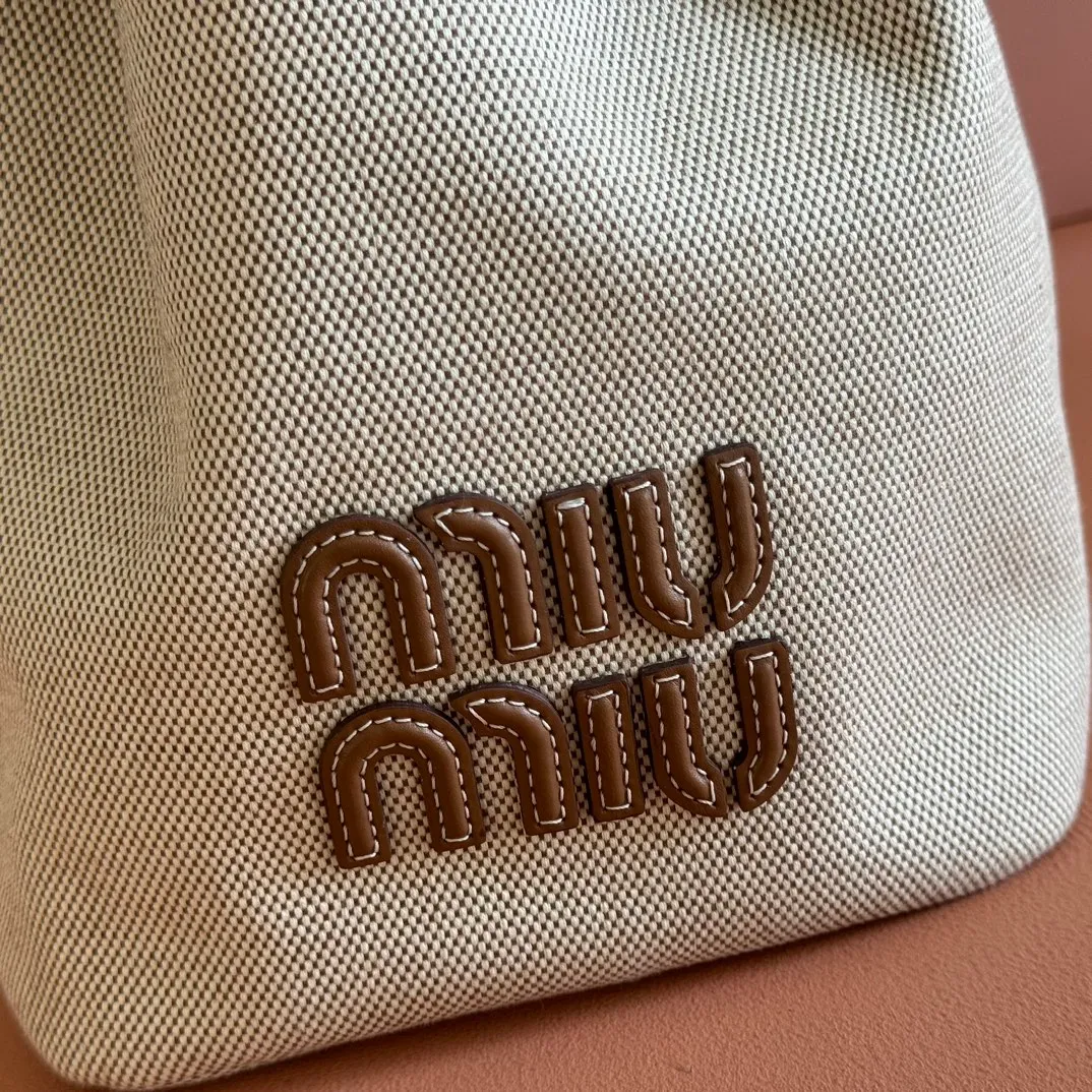 p1400💋💋💋【Full set of counter packaging】5BE089 Canvas Bucket Bag This canvas and leather bucket bag from Miu family is intertwined with contrasting materials and colors, highlighting its unique design features. The letter logo adds a unique personality to the design of this bag. Adjustable leather handles Gold-plated hardware Leather letter logo on front Leather drawstring closure Linen fabric lining Model: 5BE089 Dimensions: Height 29cm Width 17cm Length 23cm