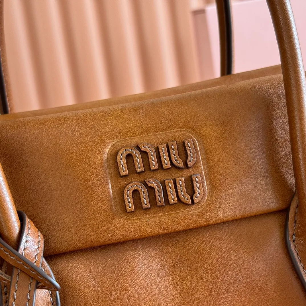p1660💋💋💋【Configuring full counter package】Vintage cow leather Solitaire small handbag: 5BA301 Structured lines and exquisite details define this handbag, inspired by MiuMiu’s 2006 archives. An elegant style that combines classic and experimental is enhanced by the iconic logo on the front and a shiny finish. ·With handles ·Front and back pockets ·Golden hardware ·With zipper pocket and patch pockets ●Front lettering logo Width: 25cm, Height: 18cm, Length: 10cm?