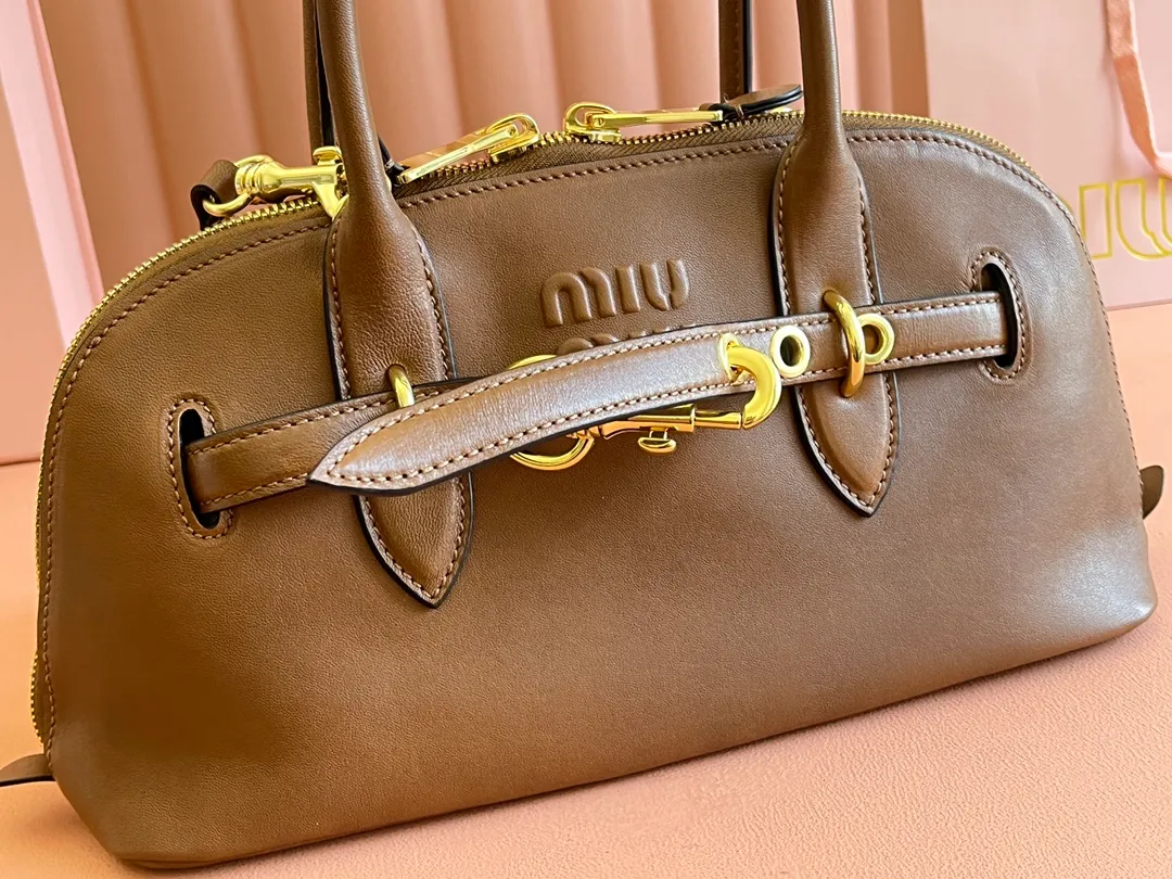 p2080💋💋💋【Original leather configuration counter packaging】Miu's new popular bowling bag, made of top-grade retro vegetable soft sheepskin, retro frosted old metal accessories, this Aventure Nappa leather handbag is inspired by A Miu collection item, its structure has been adjusted to become lighter and rejuvenate with a new personality, creating a classic bag with timeless charm. The multi-element design gives this handbag a unique beauty and classic atmosphere. It has a detachable and adjustable leather shoulder strap. The canvas lining is equipped with zipper pockets and patch pockets. Dimensions: 33 X16.5 X 10 cm. Model 5bb168