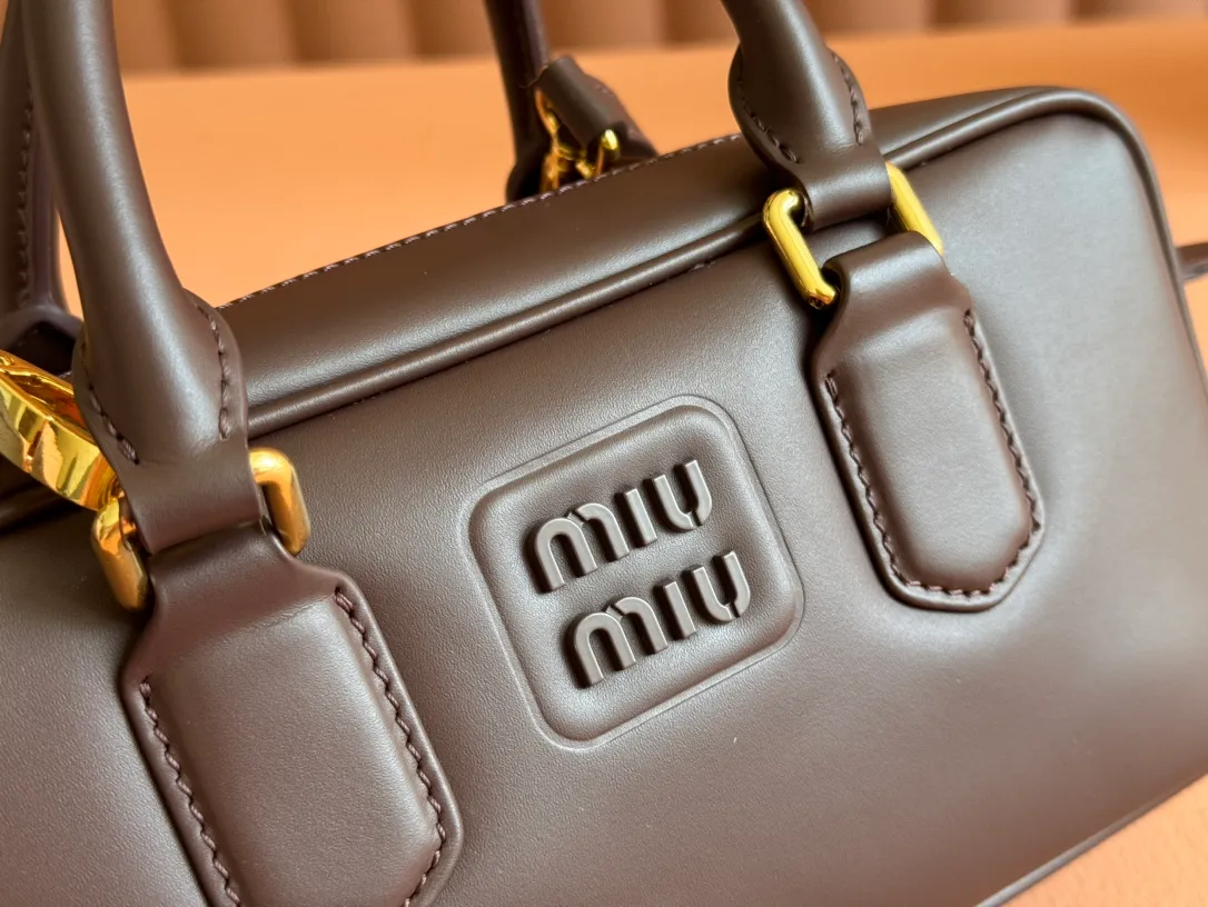 p1640💋💋💋【Full set of packaging at the counter】MIU MIU Miu Miu Caramel Bowling Upper Body Effect! Miu Miu Women's Arcadia Cowhide Handbag Crossbody Bag👝Lightly padded design makes the handbag look fuller, showing a cosmopolitan style. The letter logo, which echoes the finish of the metal hardware, straddles the line between function and decoration, giving this handbag a unique aesthetic and classic feel. Size: 22✖️10.5✖️7.5cm Style number: 5bb142 Heather color