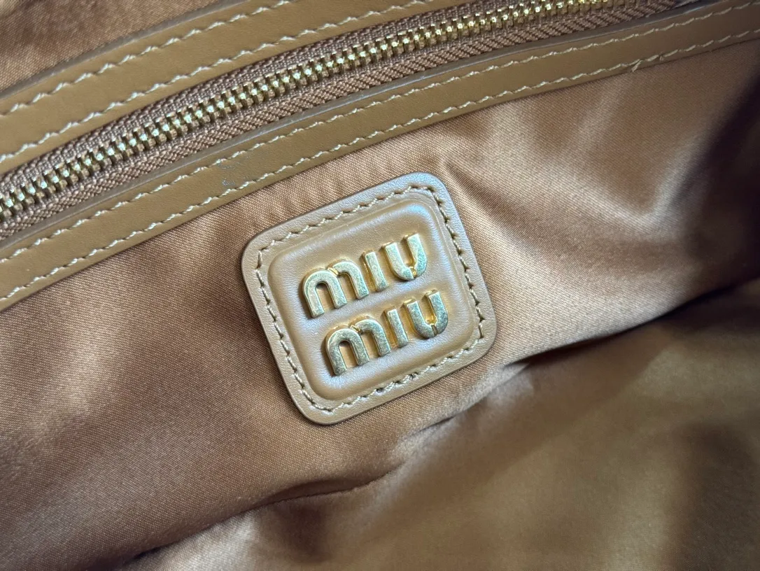 p1640💋💋💋【Full set of packaging at the counter】MIU MIU Miu Miu Caramel Bowling Upper Body Effect! Miu Miu Women's Arcadia Cowhide Handbag Crossbody Bag👝Lightly padded design makes the handbag look fuller, showing a cosmopolitan style. The letter logo, which echoes the finish of the metal hardware, straddles the line between function and decoration, giving this handbag a unique aesthetic and classic feel. Size: 22✖️10.5✖️7.5cm Style number: 5bb142 cognac color