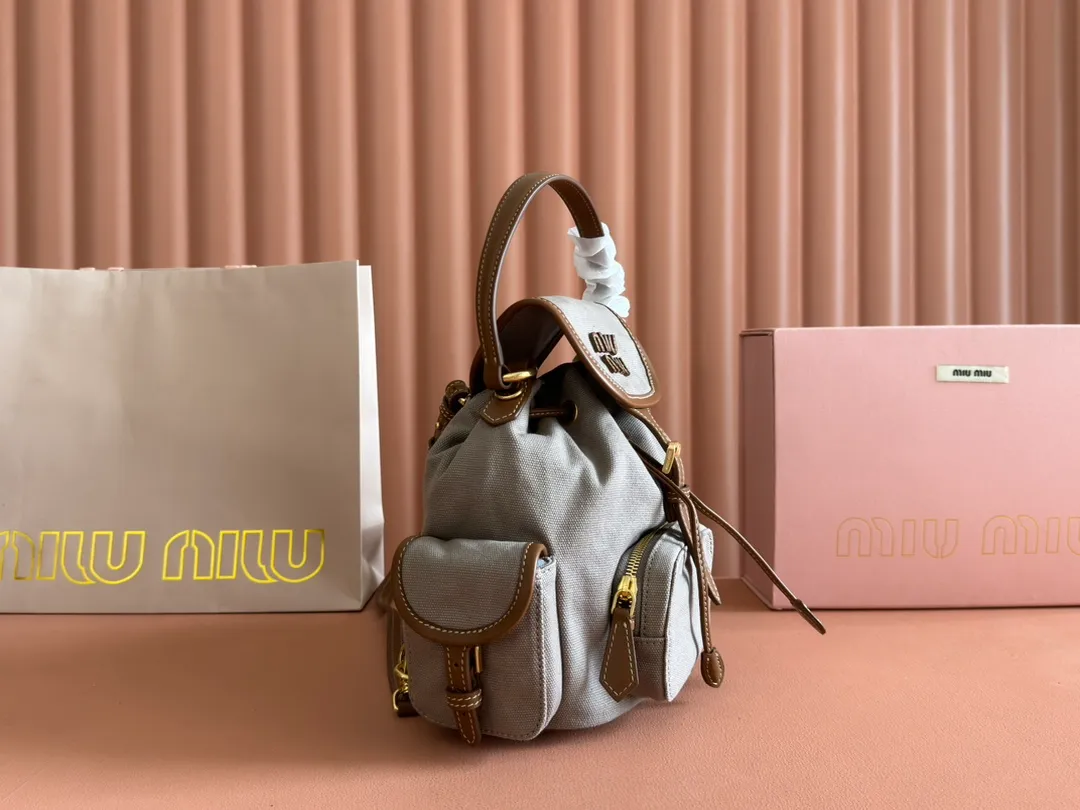 p1560. 💋💋💋【Configured with full package at counter】MIU Home new product college style backpack, the perfect combination of canvas and imported calfskin, thick wear-resistant linen blend lining, adopts a casual design style, fashionable, simple and advanced, combined with exquisite handcrafts, adds multiple pocket storage, shoulder straps and hand bags can be freely converted, greatly It improves the practicality. It is simply a tool for hanging. It can be worn with jeans, shirts or various casual sportswear. It is a very good item to wear, especially the capacity is large enough and it is light and easy to use. I sincerely recommend it. Model: 5bz043, size 22X18X11.5cm