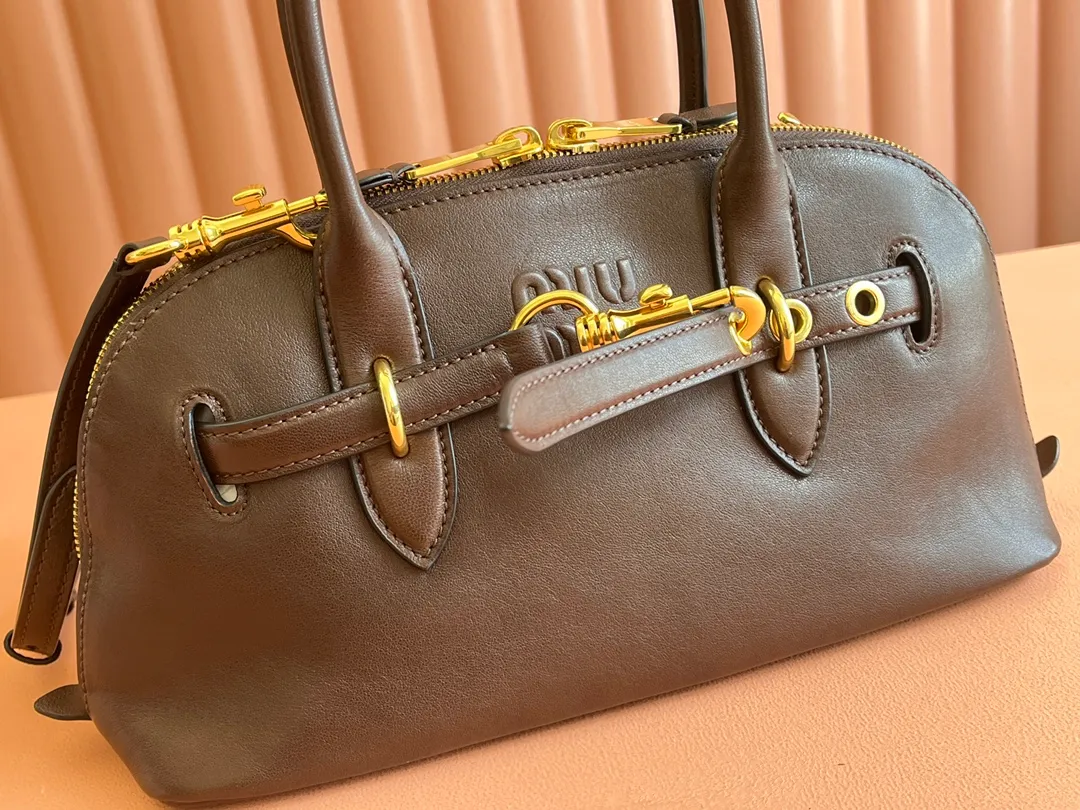 p2080💋💋💋【Original leather configuration counter packaging】Miu's new popular bowling bag, made of top-grade retro vegetable soft sheepskin, retro frosted old metal accessories, this Aventure Nappa leather handbag is inspired by A Miu collection item, its structure has been adjusted to become lighter and rejuvenate with a new personality, creating a classic bag with timeless charm. The multi-element design gives this handbag a unique beauty and classic atmosphere. It has a detachable and adjustable leather shoulder strap. The canvas lining is equipped with zipper pockets and patch pockets. Dimensions: 33 X16.5 X 10 cm. Model 5bb168