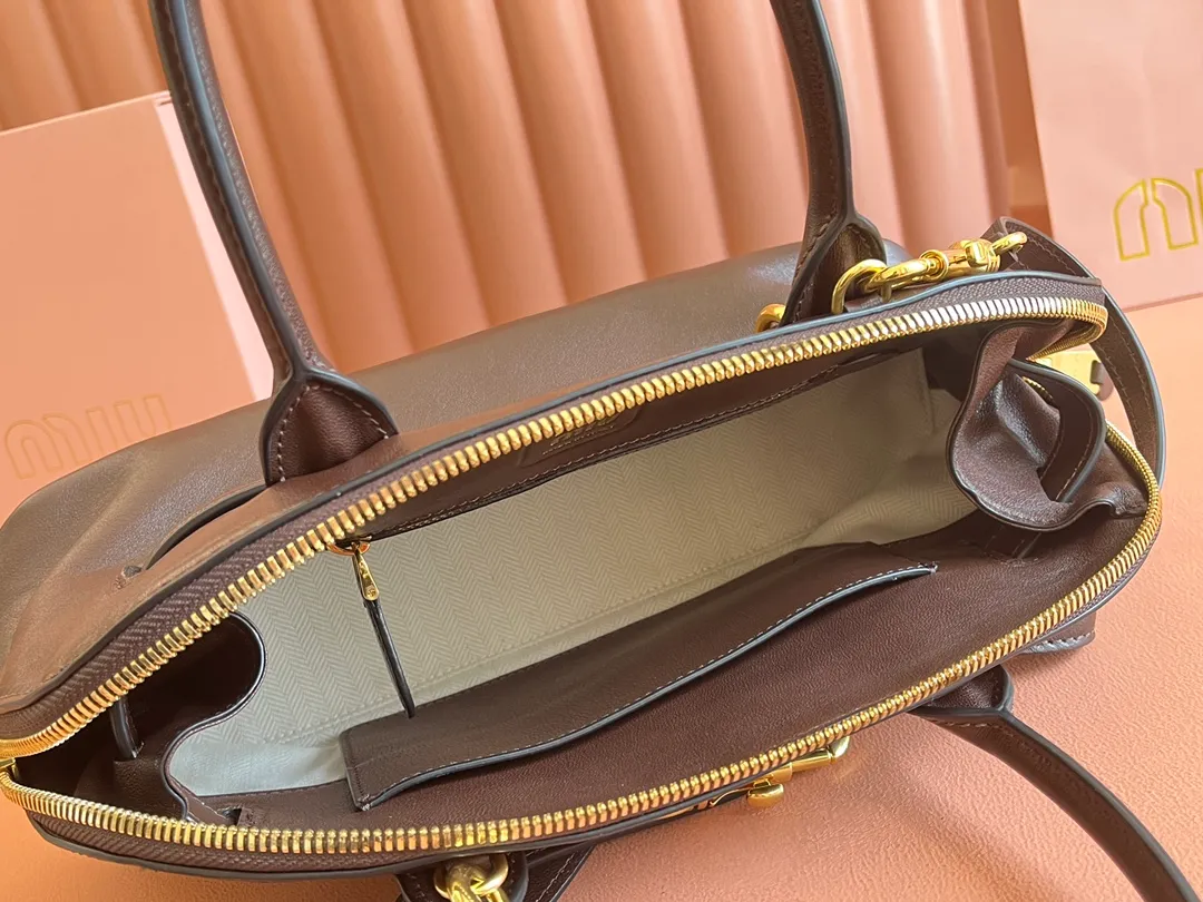 p2080💋💋💋【Original leather configuration counter packaging】Miu's new popular bowling bag, made of top-grade retro vegetable soft sheepskin, retro frosted old metal accessories, this Aventure Nappa leather handbag is inspired by A Miu collection item, its structure has been adjusted to become lighter and rejuvenate with a new personality, creating a classic bag with timeless charm. The multi-element design gives this handbag a unique beauty and classic atmosphere. It has a detachable and adjustable leather shoulder strap. The canvas lining is equipped with zipper pockets and patch pockets. Dimensions: 33 X16.5 X 10 cm. Model 5bb168
