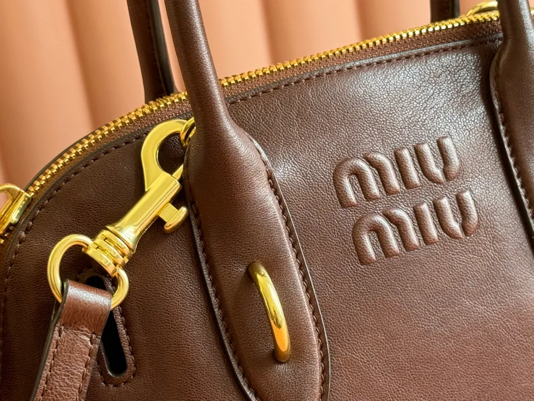 p1900💋💋💋【Original leather configuration counter packaging】Miu's new popular bowling bag, using top-grade retro vegetable soft sheepskin, retro frosted old metal accessories, this Aventure Nappa leather handbag is inspired by A Miu collection item, its structure has been adjusted to become lighter and rejuvenate with a new personality, creating a classic bag with timeless charm. The multi-element design gives this handbag a unique beauty and classic atmosphere. It has a detachable and adjustable leather shoulder strap. The canvas lining is equipped with zipper pockets and patch pockets. Dimensions: 28 X16.5 X 10 cm. Model 5bb169