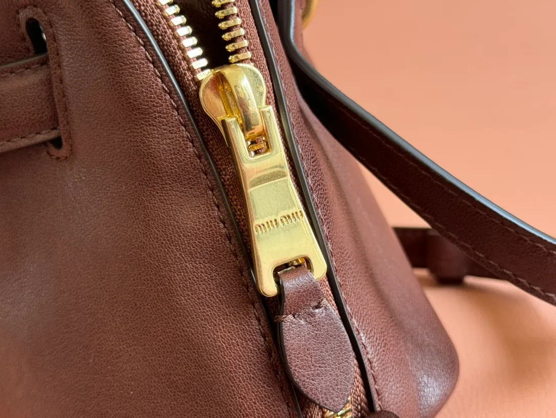 p1900💋💋💋【Original leather configuration counter packaging】Miu's new popular bowling bag, using top-grade retro vegetable soft sheepskin, retro frosted old metal accessories, this Aventure Nappa leather handbag is inspired by A Miu collection item, its structure has been adjusted to become lighter and rejuvenate with a new personality, creating a classic bag with timeless charm. The multi-element design gives this handbag a unique beauty and classic atmosphere. It has a detachable and adjustable leather shoulder strap. The canvas lining is equipped with zipper pockets and patch pockets. Dimensions: 28 X16.5 X 10 cm. Model 5bb169