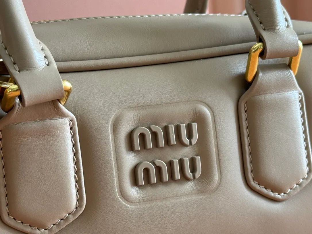 p1640💋💋💋【Full set of packaging at the counter】MIU MIU Miu Miu Caramel Bowling Upper Body Effect! Miu Miu Women's Arcadia Cowhide Handbag Crossbody Bag👝Lightly padded design makes the handbag look fuller, showing a cosmopolitan style. The letter logo, which echoes the finish of the metal hardware, straddles the line between function and decoration, giving this handbag a unique aesthetic and classic feel. Size: 22✖️10.5✖️7.5cm Style number: 5bb142 bean paste