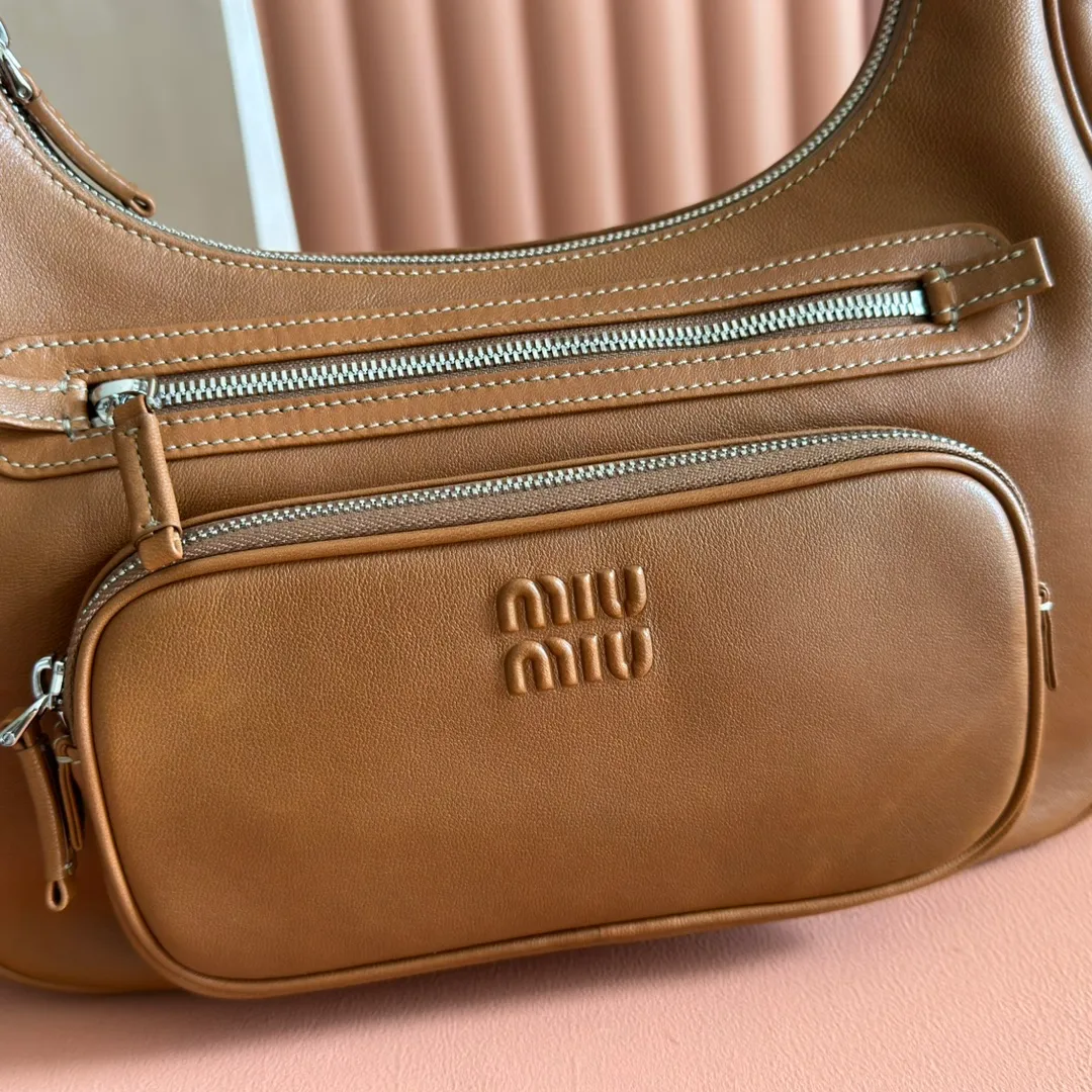 p2200💋💋💋【Full set of packaging at the counter】𝗠𝗶𝘂 𝗠𝗶𝘂 𝗣𝗼𝗰𝗸𝗲𝘁Motorcycle bag This MIU pocket bag is so big that even a rich family’s daughter is carrying it! Full leather inside and out, the leather is very soft and feels super good. The Tori zipper + three-dimensional pockets are retro and can be carried in one bag under the arm to unlock two ways of carrying it. Fashionable girls, please plant this motorcycle bag! Size: 38cm long (measured including the 2 side pockets, 33cm excluding it) Style number: 5BC189 caramel color Dimensions: length 38×width 14×height 20cm