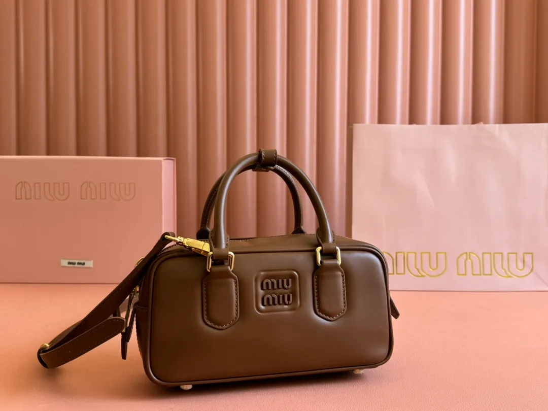 p1640💋💋💋【Full set of packaging at the counter】MIU MIU Miu Miu Caramel Bowling Upper Body Effect! Miu Miu Women's Arcadia Cowhide Handbag Crossbody Bag👝Lightly padded design makes the handbag look fuller, showing a cosmopolitan style. The letter logo, which echoes the finish of the metal hardware, straddles the line between function and decoration, giving this handbag a unique aesthetic and classic feel. Size: 22✖️10.5✖️7.5cm Style number: 5bb142 brown