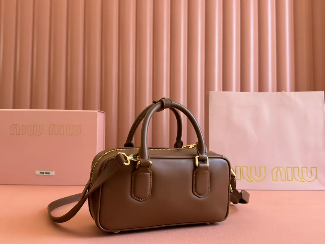 p1640💋💋💋【Full set of packaging at the counter】MIU MIU Miu Miu Caramel Bowling Upper Body Effect! Miu Miu Women's Arcadia Cowhide Handbag Crossbody Bag👝Lightly padded design makes the handbag look fuller, showing a cosmopolitan style. The letter logo, which echoes the finish of the metal hardware, straddles the line between function and decoration, giving this handbag a unique aesthetic and classic feel. Size: 22✖️10.5✖️7.5cm Style number: 5bb142 brown